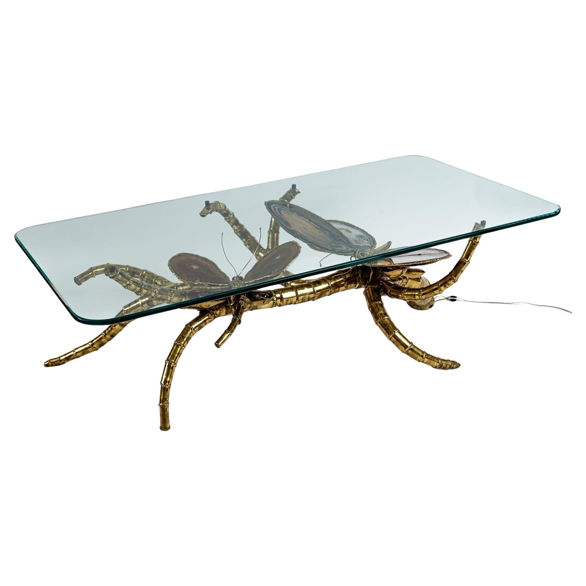 Une étonnante table basse sculpturale faite de laiton de bambou et de papillons illuminés complexes entourés d'ailes et d'yeux en agate bleu-gris véritable.

Chaque aile  s'allume.

Origine :  France Pour Maison Honoré Paris

Datation :