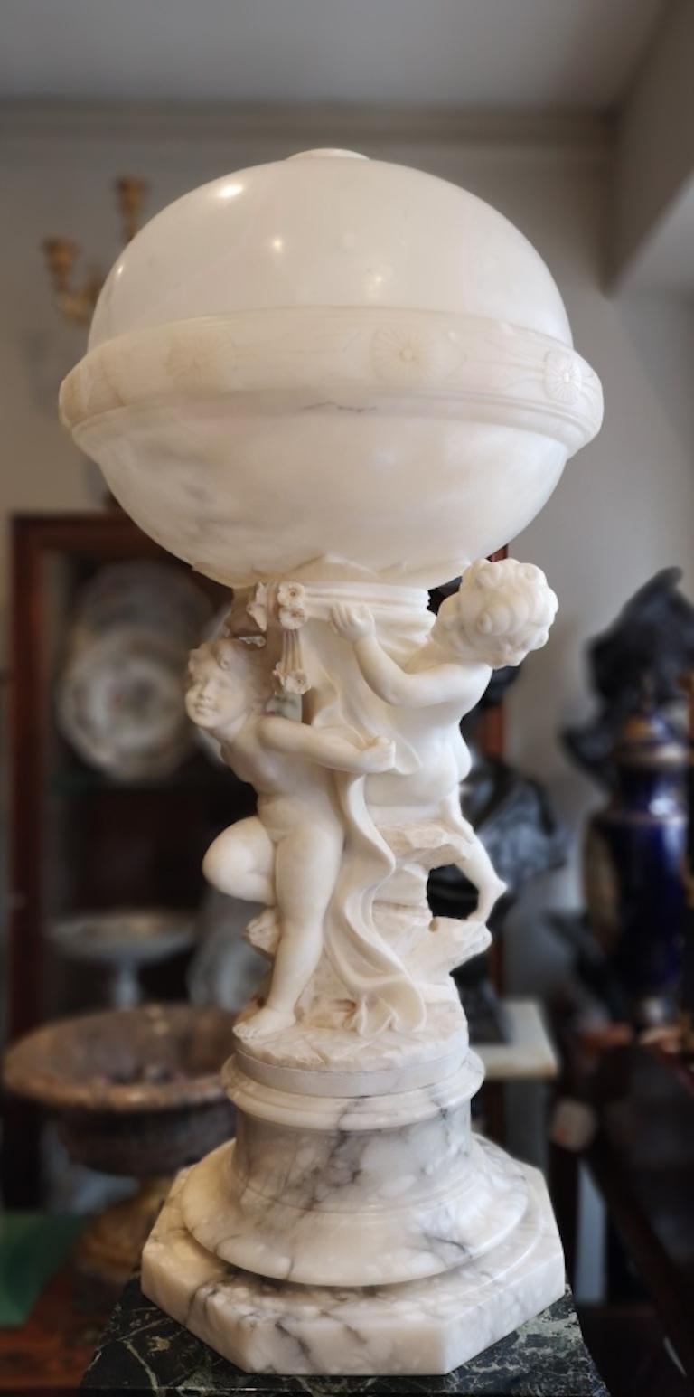 Large French Alabaster Sphere lamp with putti, 1910

A magnificent early 20th century French alabaster sculpture lamp. 
The large alabaster sphere enclosing the lightbulb. Supported by two putti with drapery and flowers. On an octagonal base. A
