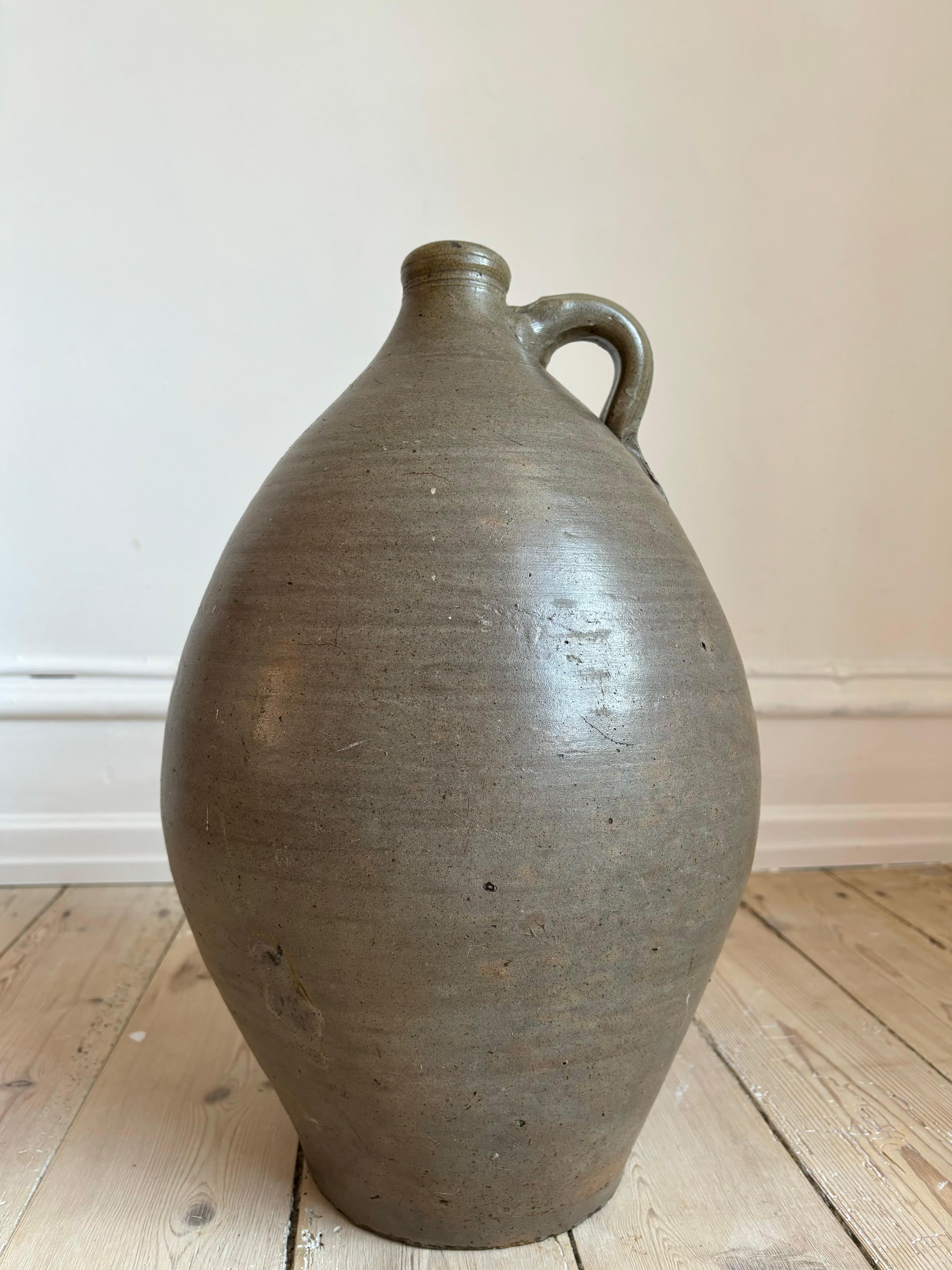 Very large authentic 19th century glazed terracotta pitcher bottle jug originally used for containing water or olive oil. Beautifully aged and weathered with stunning glaze in warm hippopotamus gray and earthy sage green nuances. 
France, circa