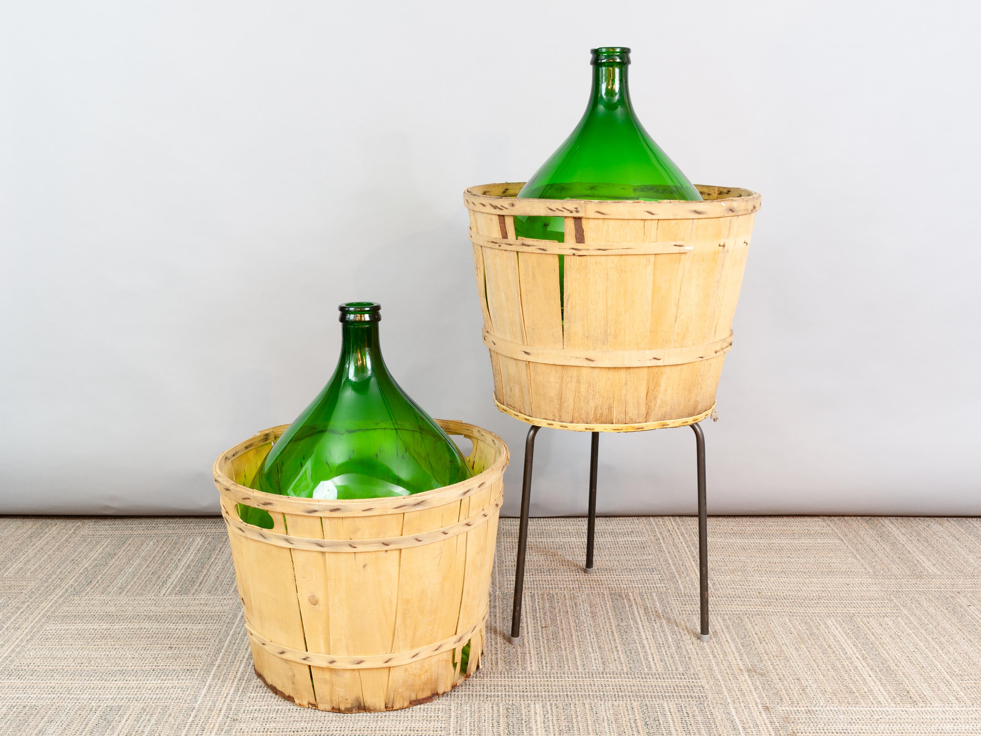 Large French antique emerald green demi-john in its original wooden carrying basket. The bottle can be used for decorative purposes only or for the storing of wine or perhaps olives. They make a wonderful centre-pieces for a large table display,