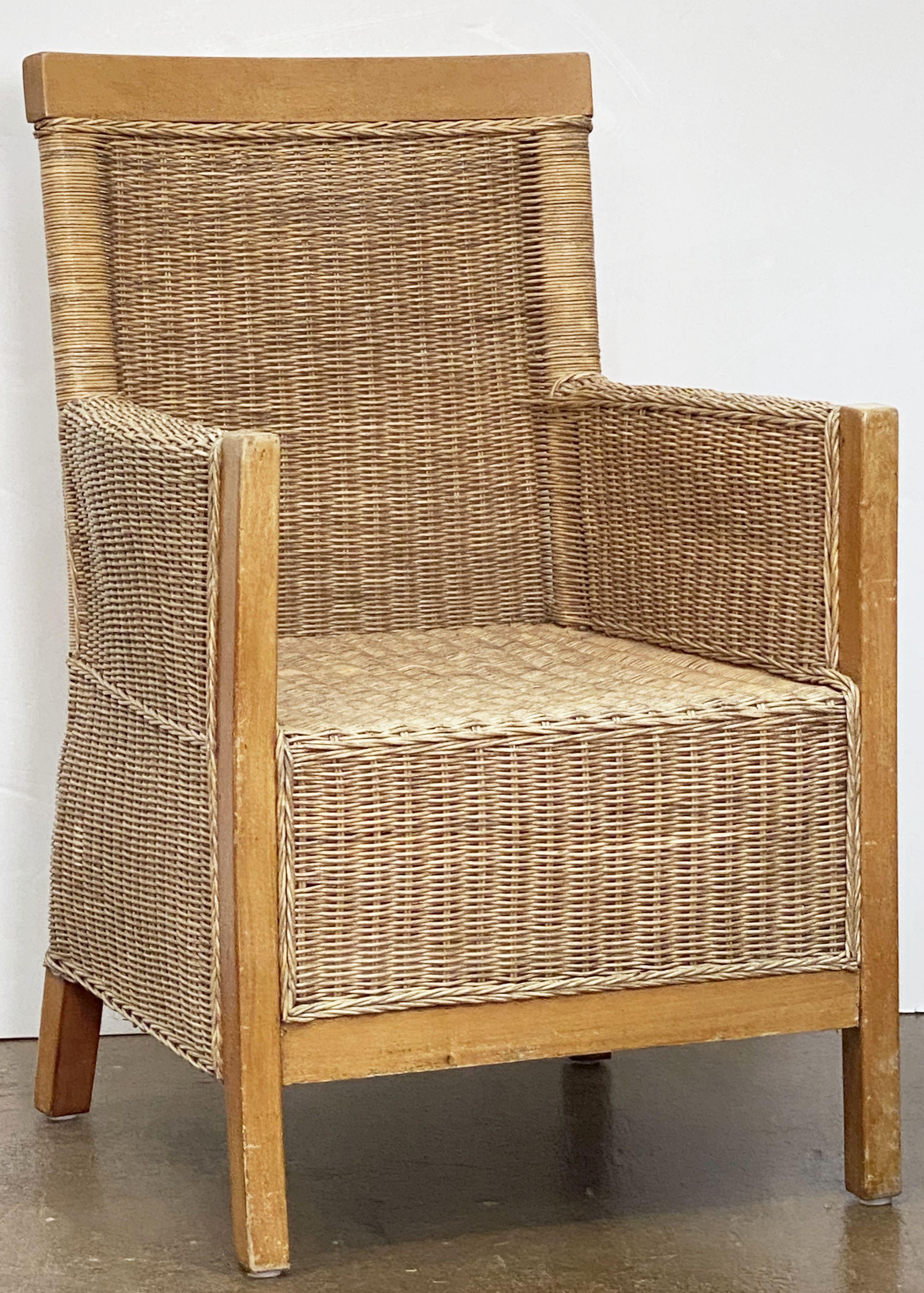 A fine large French armchair or lounge chair of woven wicker cane and beechwood featuring a comfortable back and seat and a sturdy modern design.

Two available.