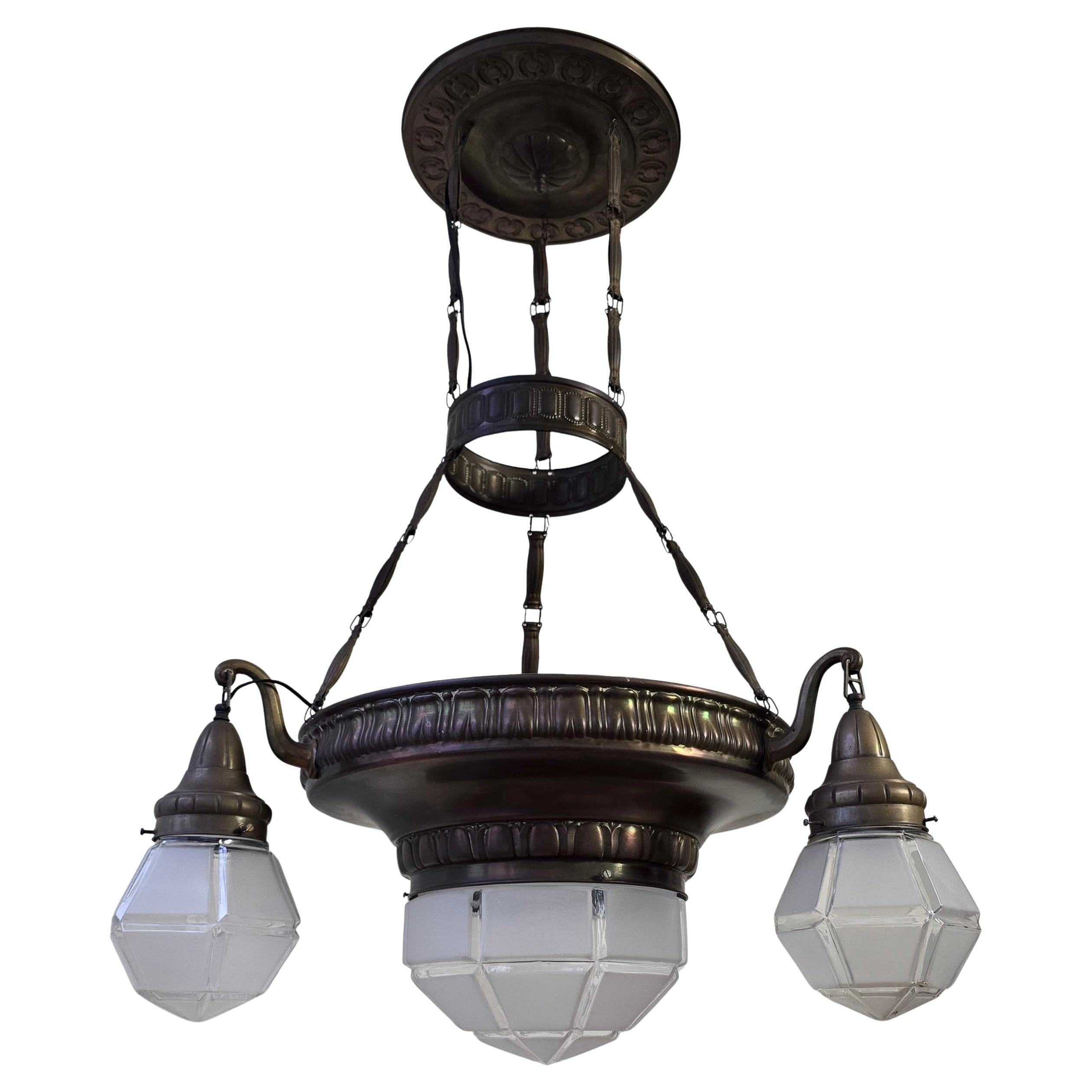Elegante lampadario francese Art Déco di grandi dimensioni in ottone patinato con quattro paralumi geometrici in vetro smerigliato, circa 1930. Un design architettonico raffinato con un'ottima fattura e proporzioni equilibrate.

Grande e raffinato