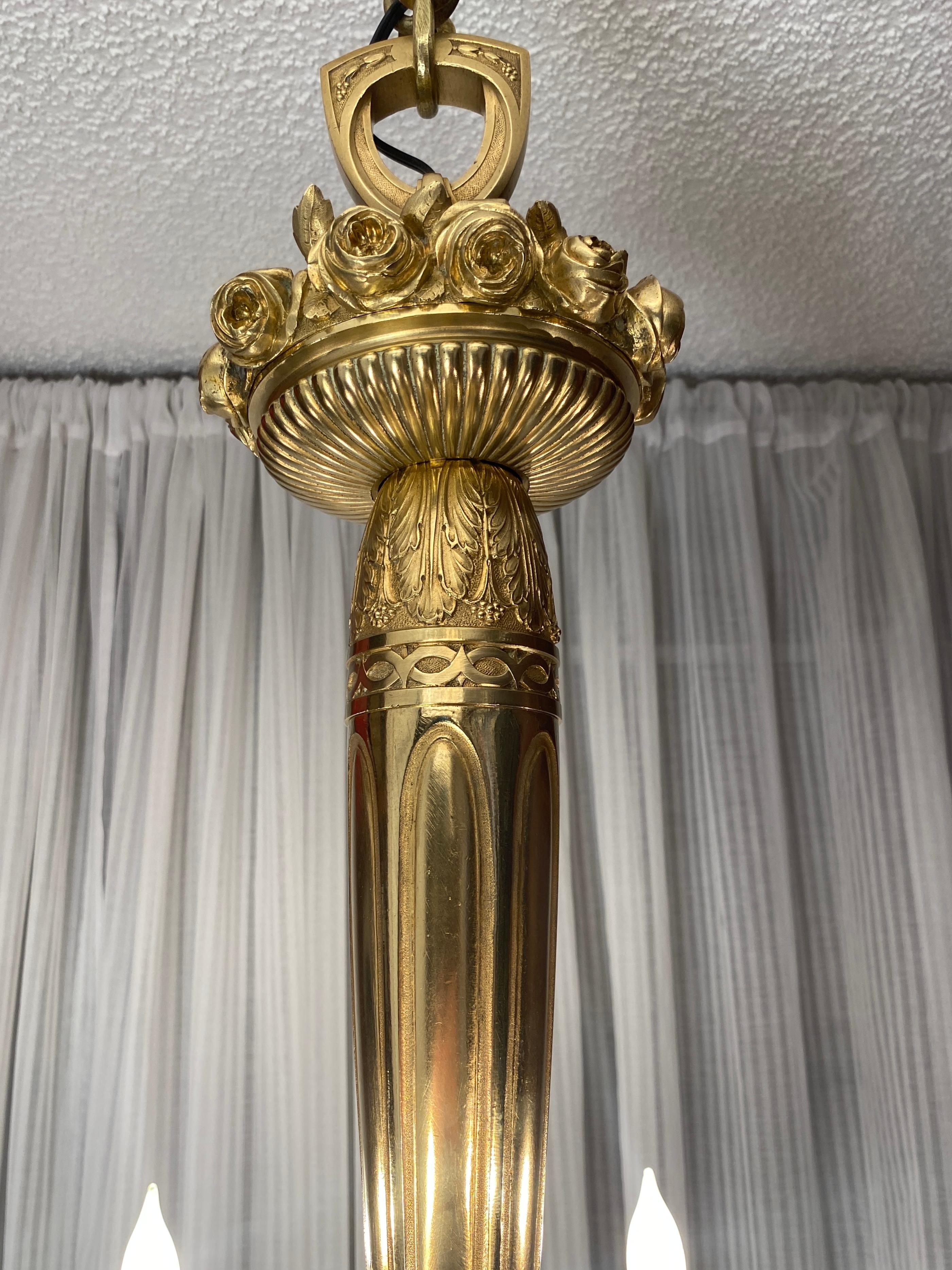 Raro e straordinario lampadario francese Art Déco in bronzo con disegni geometrici e floreali, con 6 bracci a voluta che si irradiano da una sfera centrale con disegno a rilievo e un terminale a ghianda.  Attribuito a designer francesi 
Sue et