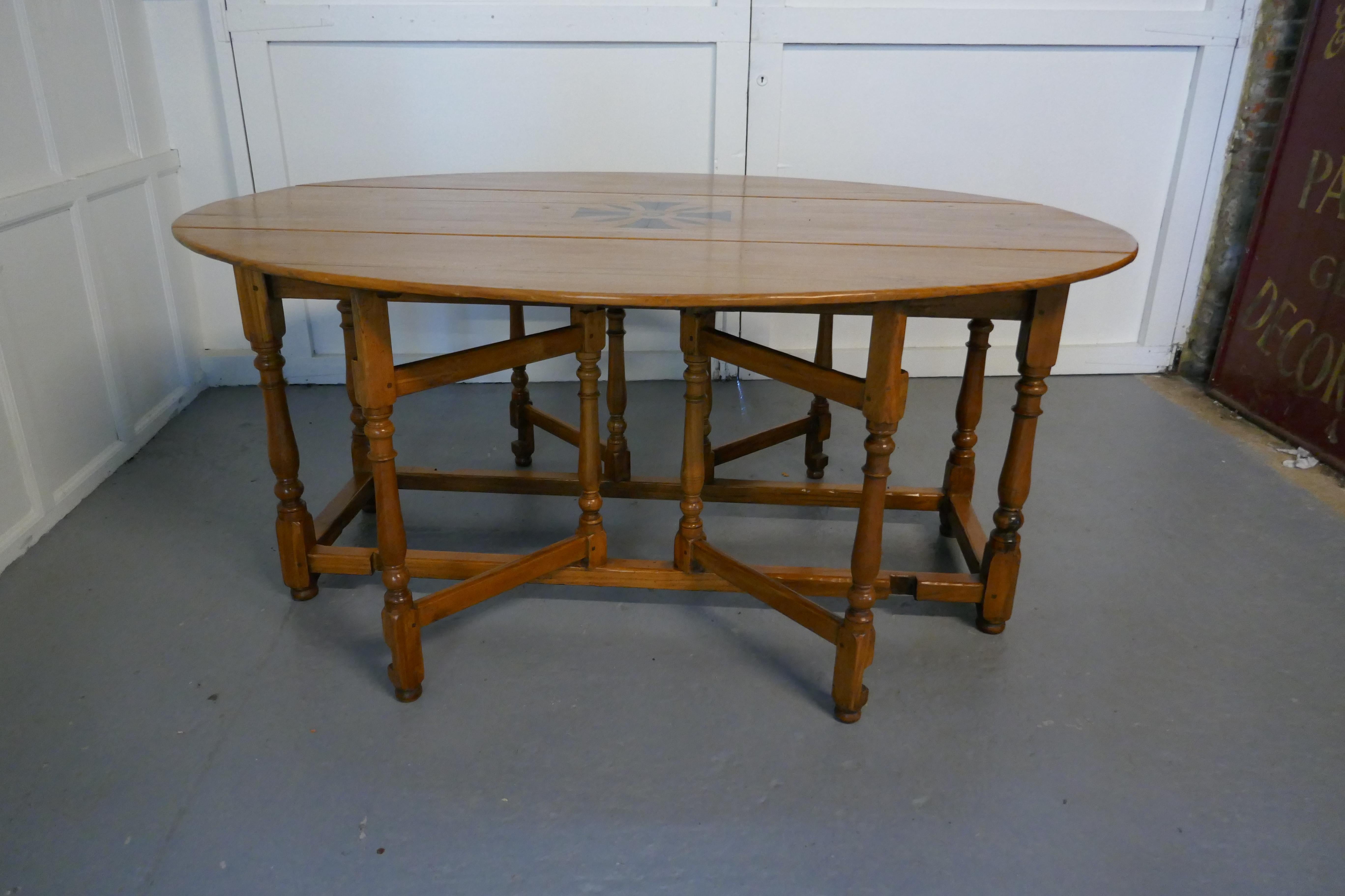 Large French Art Deco lemon wood gate leg wake table

This is a large table with double gate leg at each side to support the long deep leaves, there is a marquetry design in the centre, it has attractive turned legs and cross members
The table