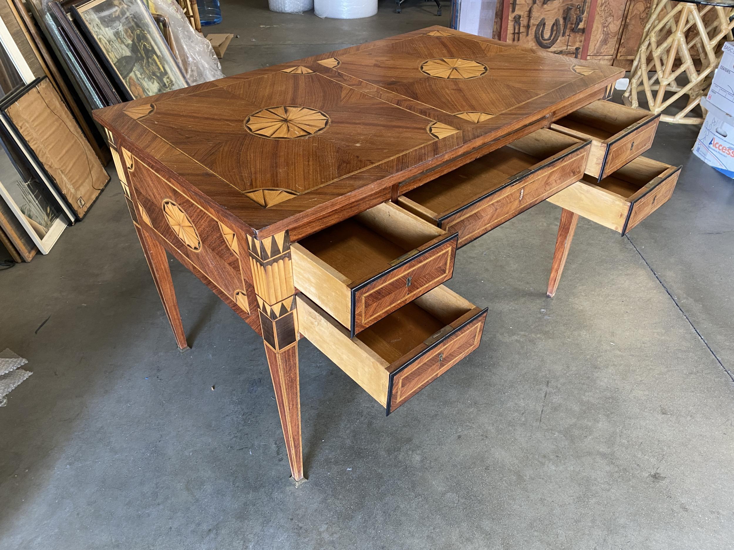 An exceptional French parquetry inlaid writing table with art deco designs, inlay with satinwood, black walnut, and geometric patterns. Having a single center drawer with 4 side drawers, and supported on tapering legs.

 