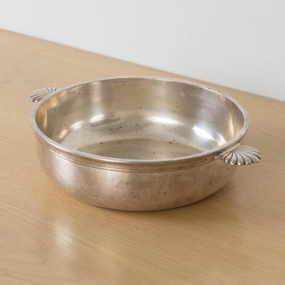 Magnifique bol en métal argenté Art Déco, France, années 1930. Coupe basse avec rainures sur le pourtour et jolies poignées décoratives en forme de coquillage. La finition d'origine présente une belle patine d'âge. Parfait comme objet décoratif ou