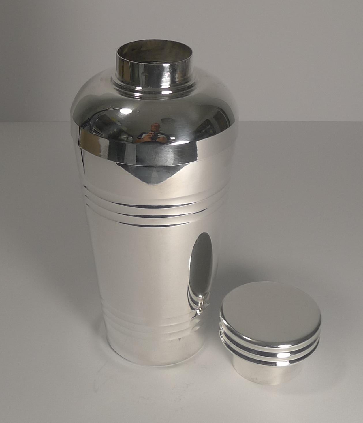 A very strong shape and design was adopted to create this large Art Deco cocktail Shaker dating to circa 1930.

Our silversmith has professionally cleaned and polished it to create a piece in excellent condition. The pull off top retains it's