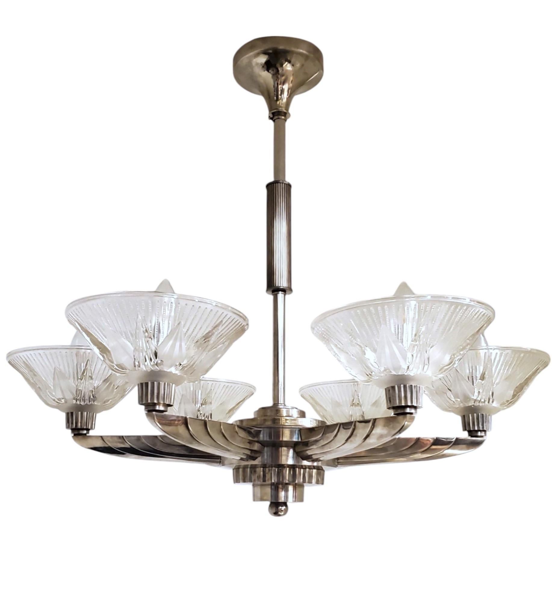 
This large and exquisite French Machine Age polished nickel bronze chandelier by Petitot epitomizes the elegance and innovation of the Art Deco period.  Featuring six sizeable 8