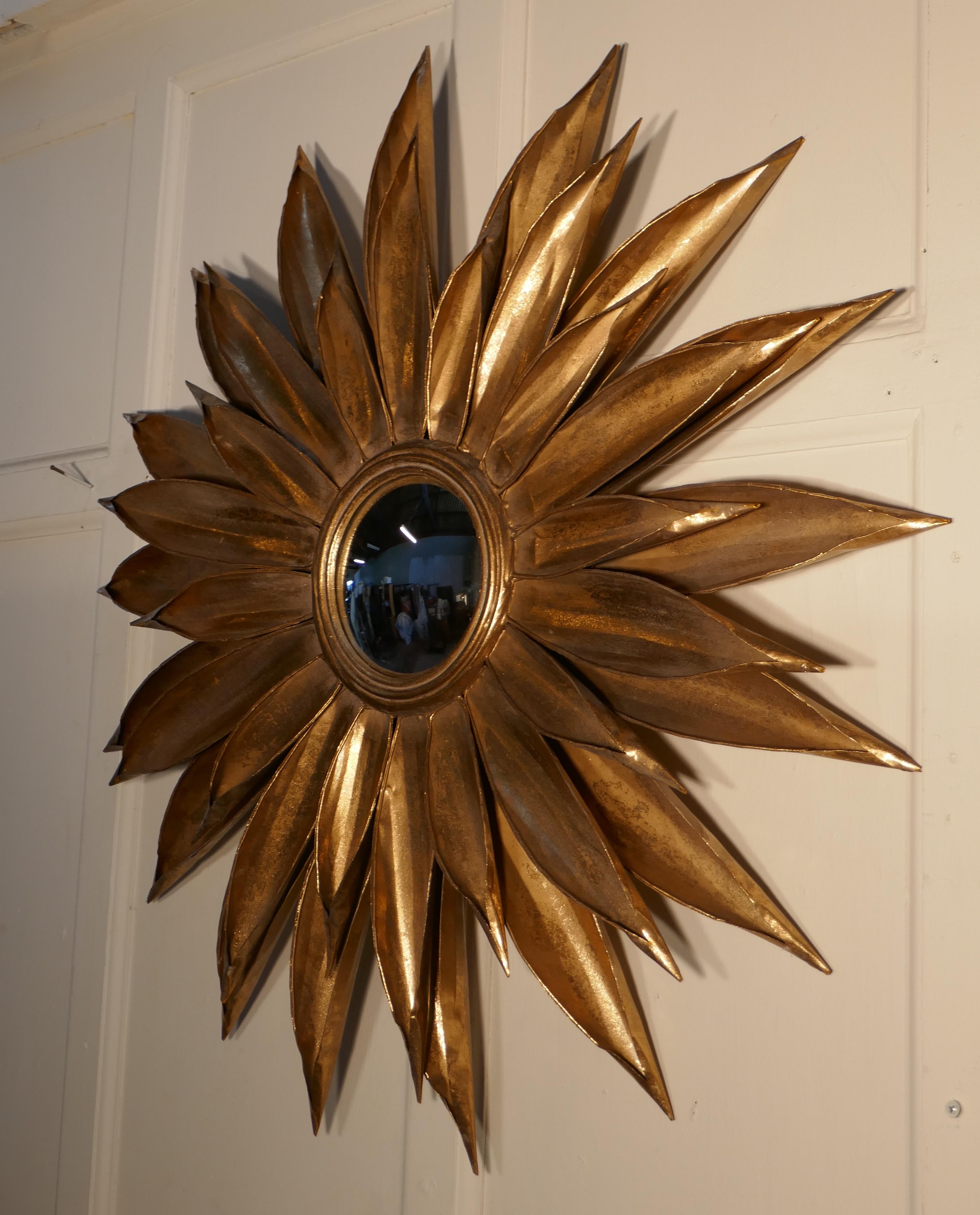 Large French Art Deco sunburst-starburst toleware convex gilt mirror

A superb piece, the large starburst or sunburst radiates out from the central convex mirror, the rays are in gold toleware, they take the form of large folded petals, in four