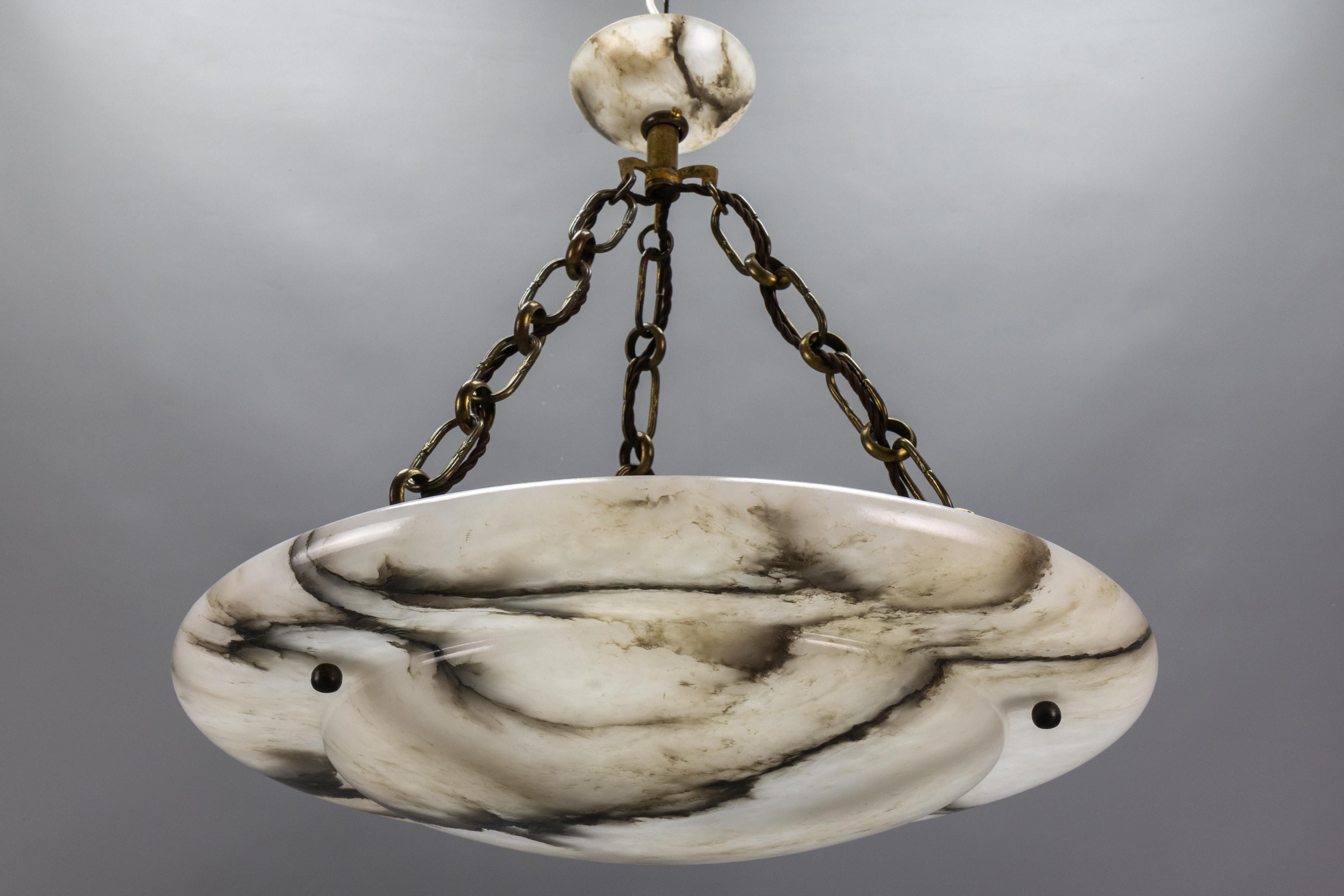 Large French Art Deco black and dark brown veined white alabaster three-light pendant chandelier.
It is an elegant piece from around 1920. It features a beautifully shaped white alabaster bowl with darker tones and spectacular, dimensional dark