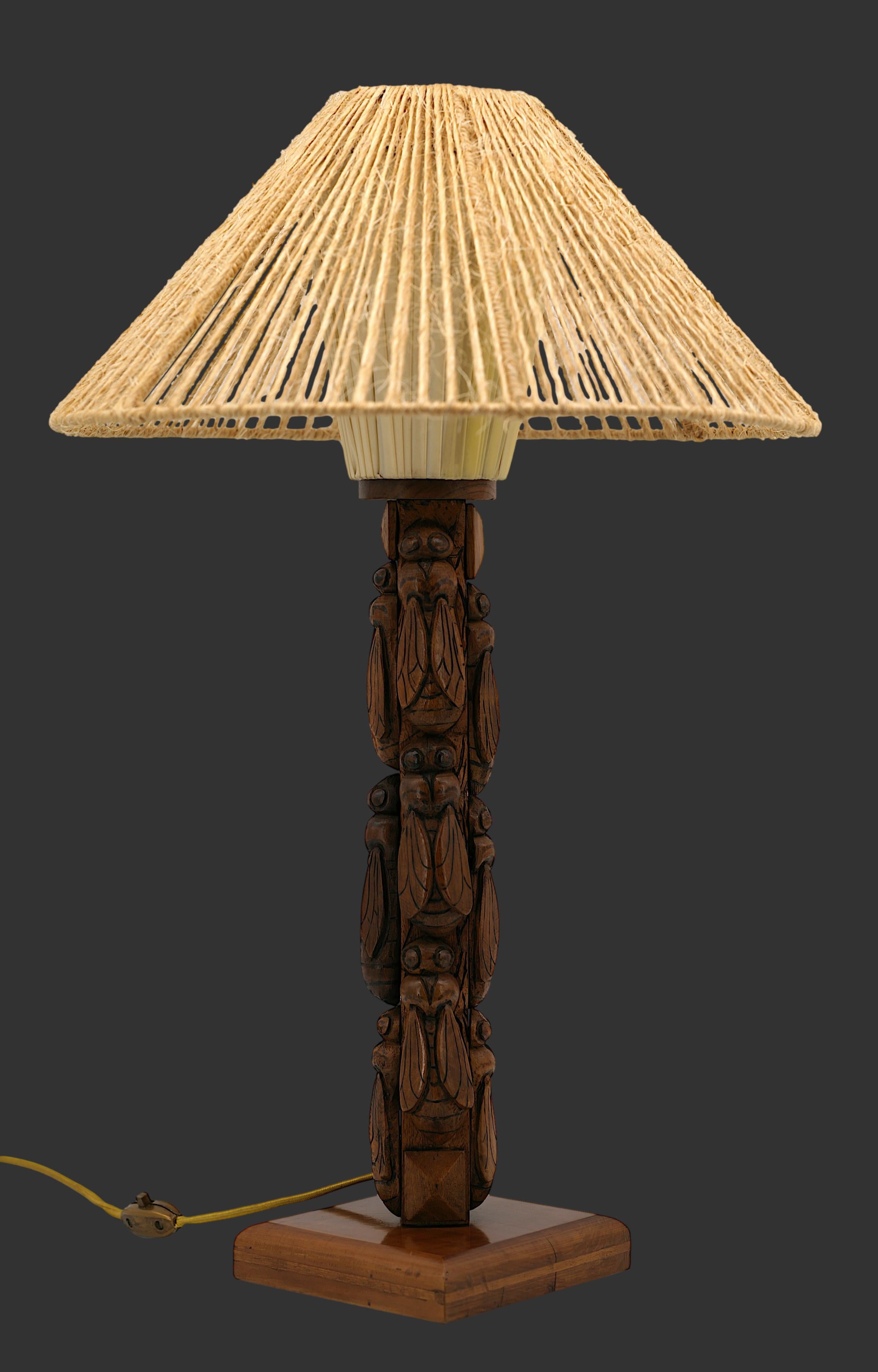 Gran lámpara de mesa francesa Art Déco, Francia, años 30. Base de madera decorada con 12 cigarras talladas. La pantalla consta de una carcasa exterior de cuerdas que rodea una pantalla/reflector de tejido sintético. Altura con pantalla : 63 cm