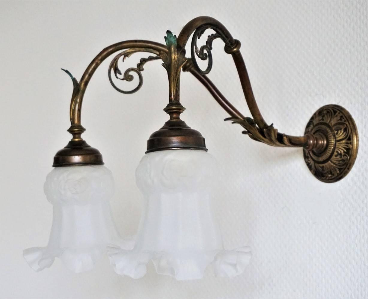 A lovely Art Nouveau bronze and brass two-light wall sconce decorated with foliage, frosted art glass shades, circa 1900-1910, with wonderful patina. The wall sconce has been rewired.
Measures: Width: 15.75 in (40 cm)
Depth: 15.75 in (40