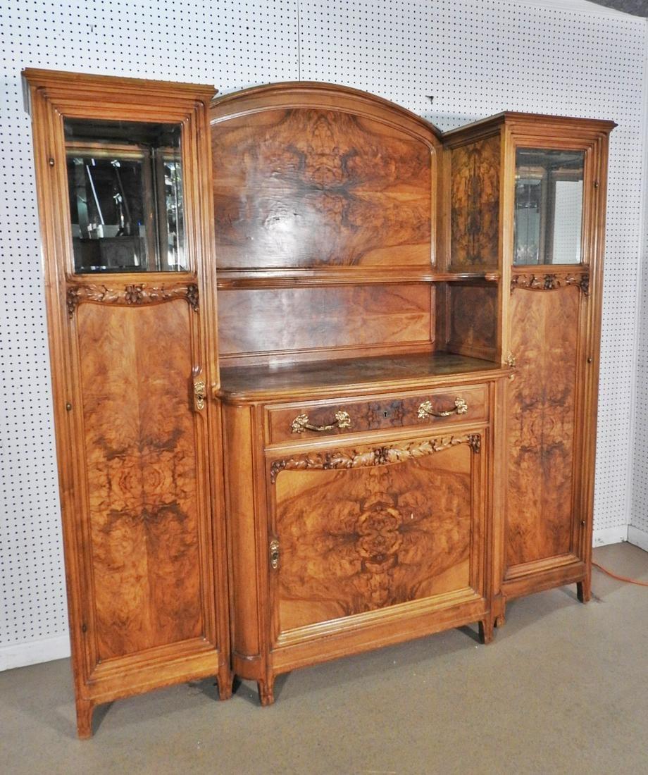 3 pieces. Metal hardware. 2 doors on sides containing beveled glass tops and containing 3 wood shelves and mirrored shelf. One dovetailed drawer. One door in center containing 1 shelf. Carved. Measures approximately 82 wide x 81 tall x 24 deep.