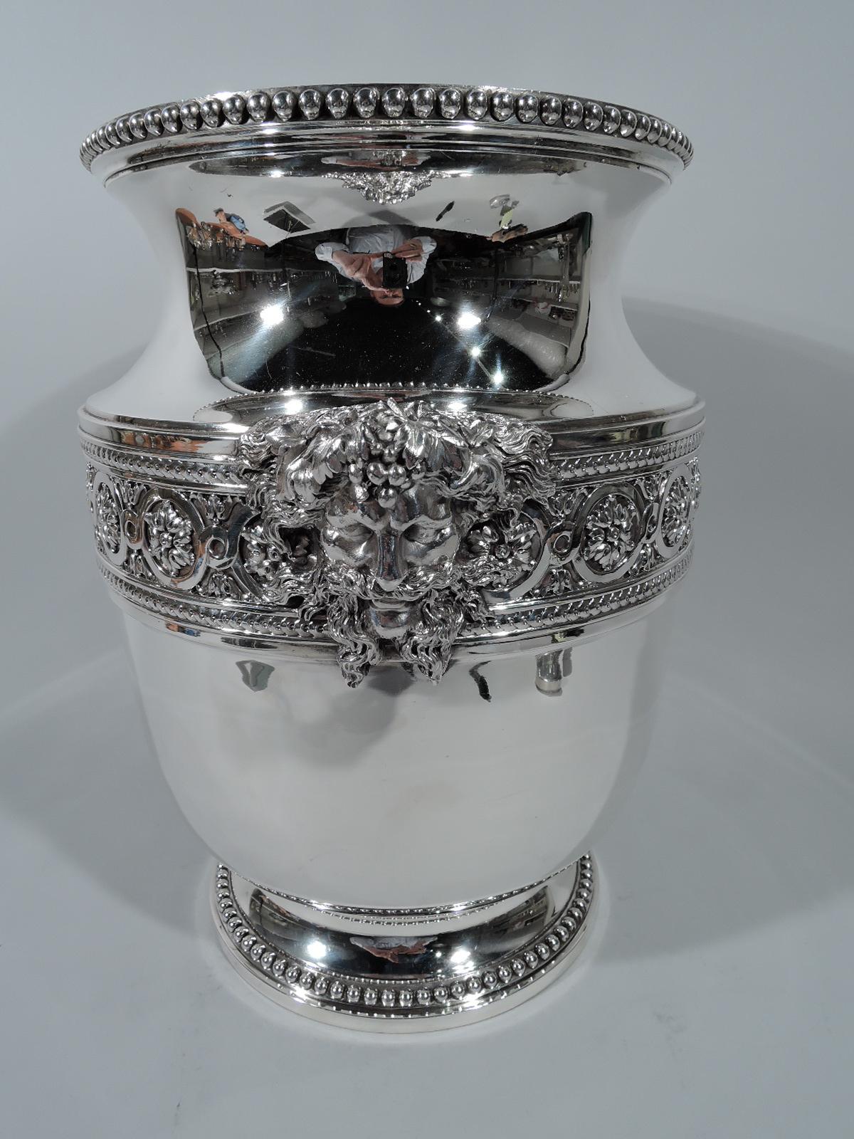 Belle Epoque 950 silver wine cooler. Made by Ravinet & D’Enfert in Paris. Urn with raised foot and flared rim. Chased band with rosette-inset guilloche band between threaded-disc borders. Beaded rims. Substantial and restrained with a suggestion of
