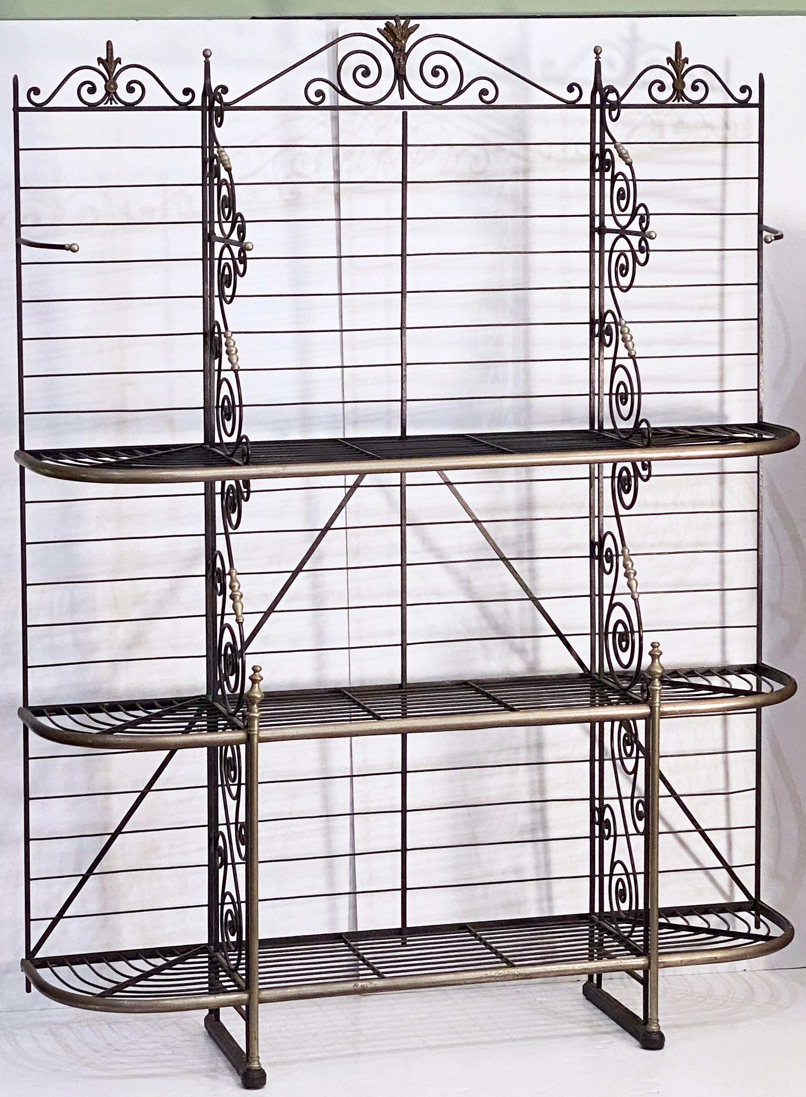 A large French baker's rack boulangerie or patisserie display stand of wrought iron with decorative brass and nickel trim - featuring a beautiful frame with scrolled dividing panels, topped with finials and detailed gilded sheaves of wheat, and