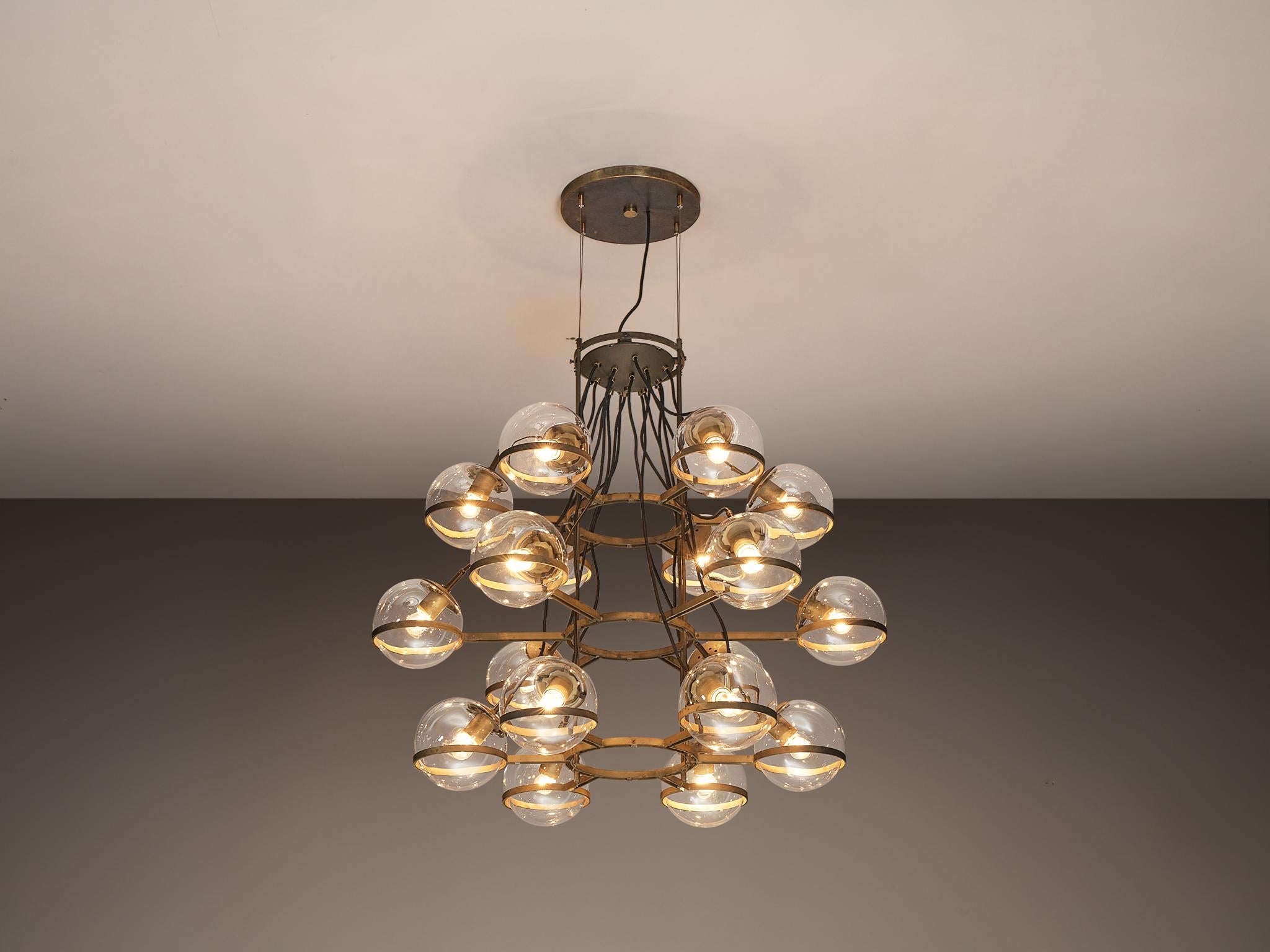 Large chandelier, brass, glass, France, 1960s.

A gorgeous French multi-layered chandelier from the 1960s. This exquisite piece features a patinated brass fixture with eighteen arms, each adorned with a glass sphere. Its design is enhanced by