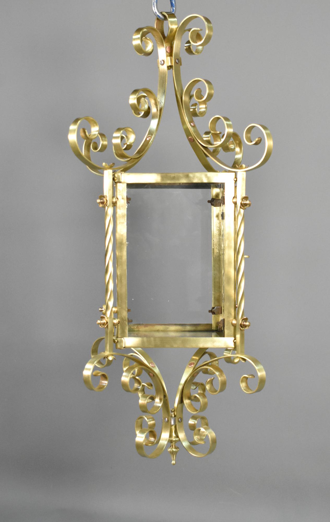 Grande lanterne française en laiton 

Cette grande lanterne attrayante en laiton présente une cage oblongue vitrée avec des volutes en C sur les parties supérieure et inférieure. 

Une porte ouvrante sur un côté permet d'accéder facilement à