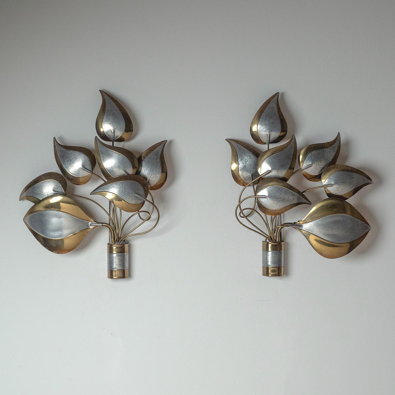 Pair of large French brass wall lights from the 1960-1970s. Seven ‚free-floating‘ brass leaves in varying sizes are attached to undulating brass wires from a slim centerpiece. Nice original condition with some patina on the brass. One original E14