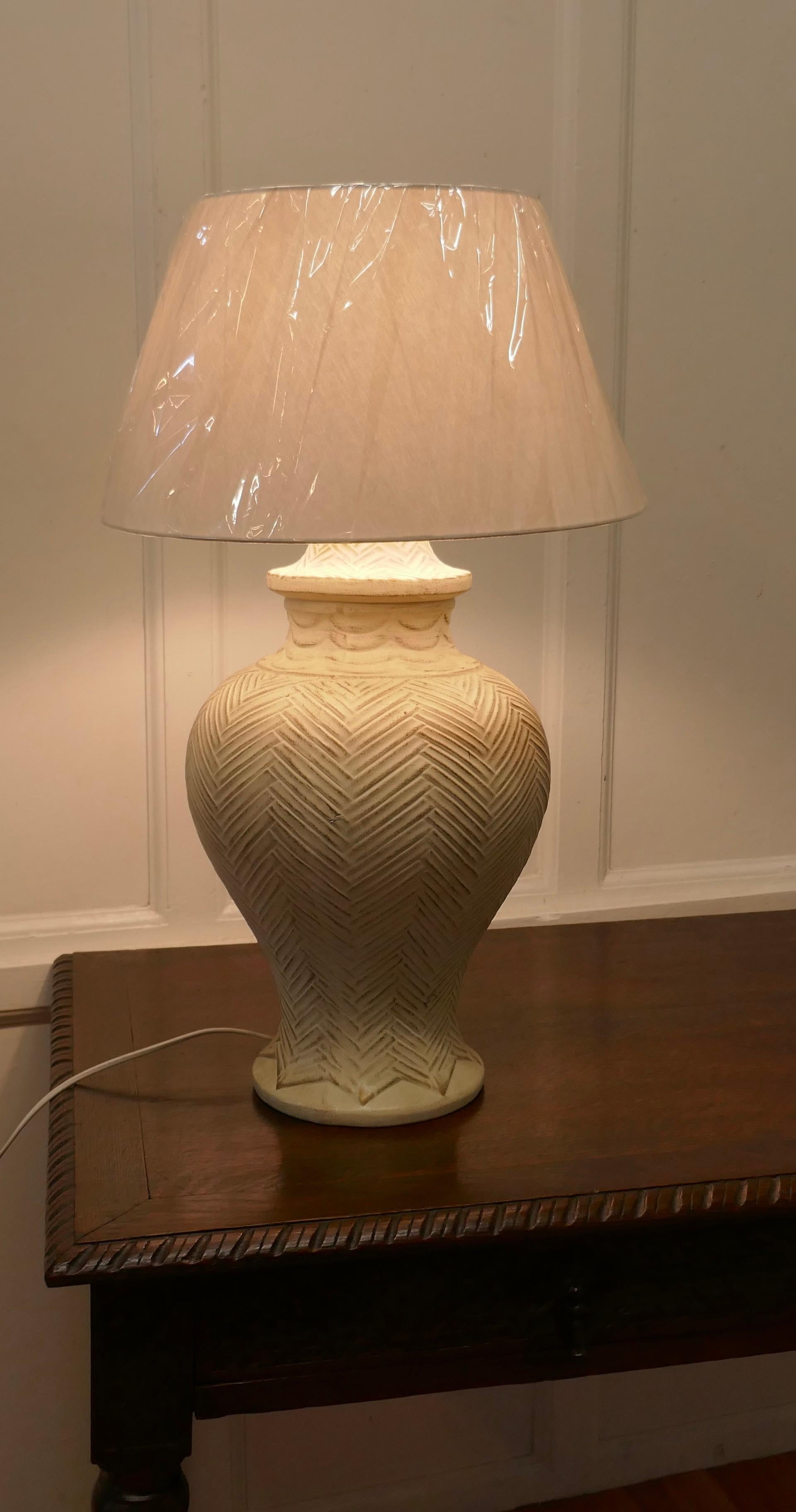 Large French Bulbous pottery table lamp 

The lamp is a large ceramic urn shape which has a herringbone decoration, it is topped of with a new lampshade 
The lamp and shade are in good used condition, the wiring is relatively new
The lamp is 26”