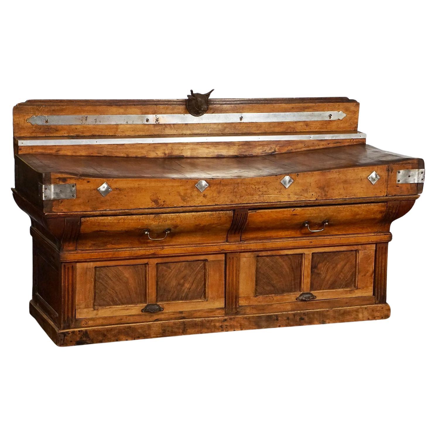 A fine large French butcher's chopping block or double billot de boucher from the late 19th century - with fixed wood backsplash that features a cast iron steer head mount in the center and steel accents. Large rectangular chopping block of mixed