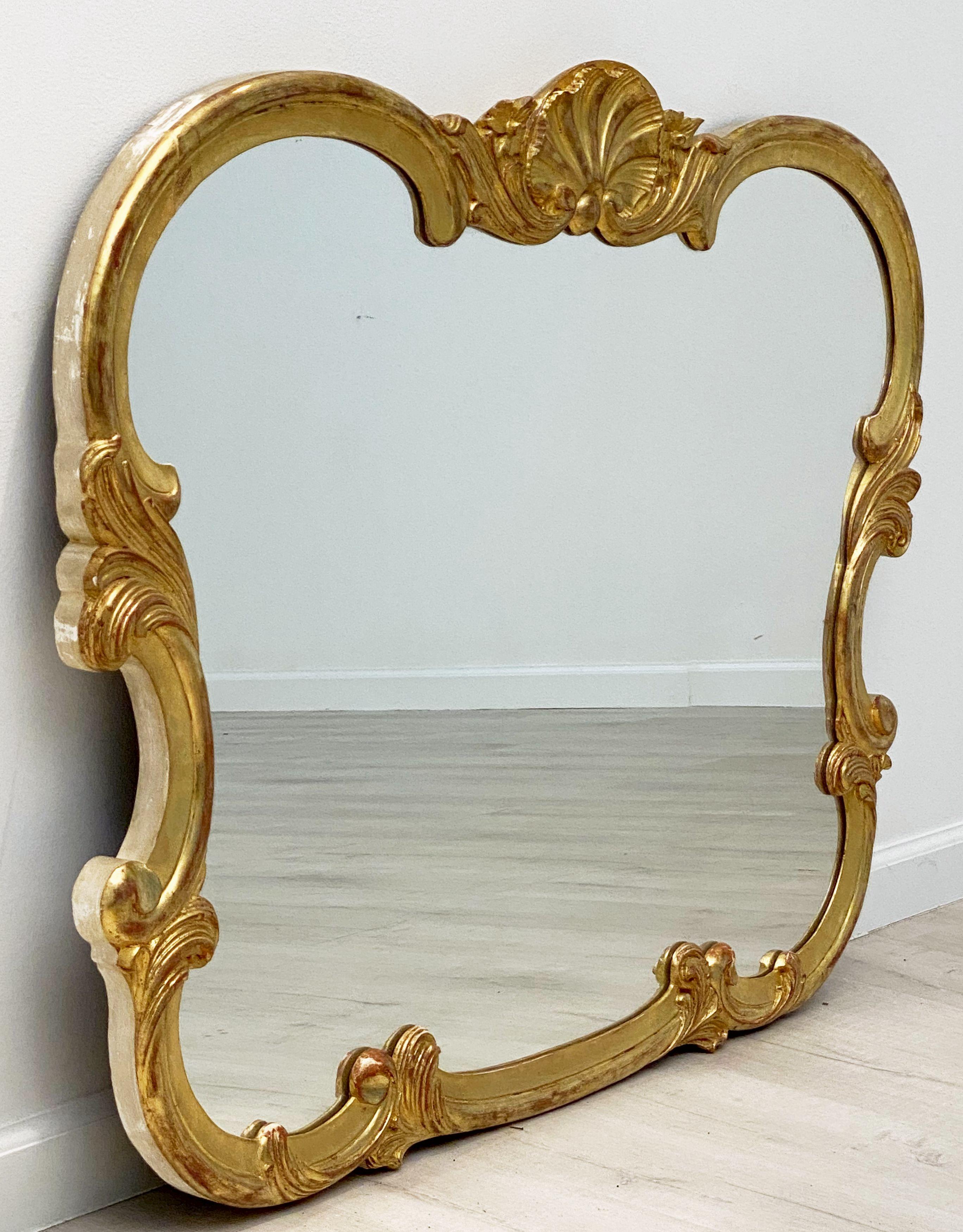 A fine large French wall mirror featuring a gilded wood frame carved with seashell crest and lovely scrollwork detail. 

Dimensions are H 33 3/4 inches x W 47 inches