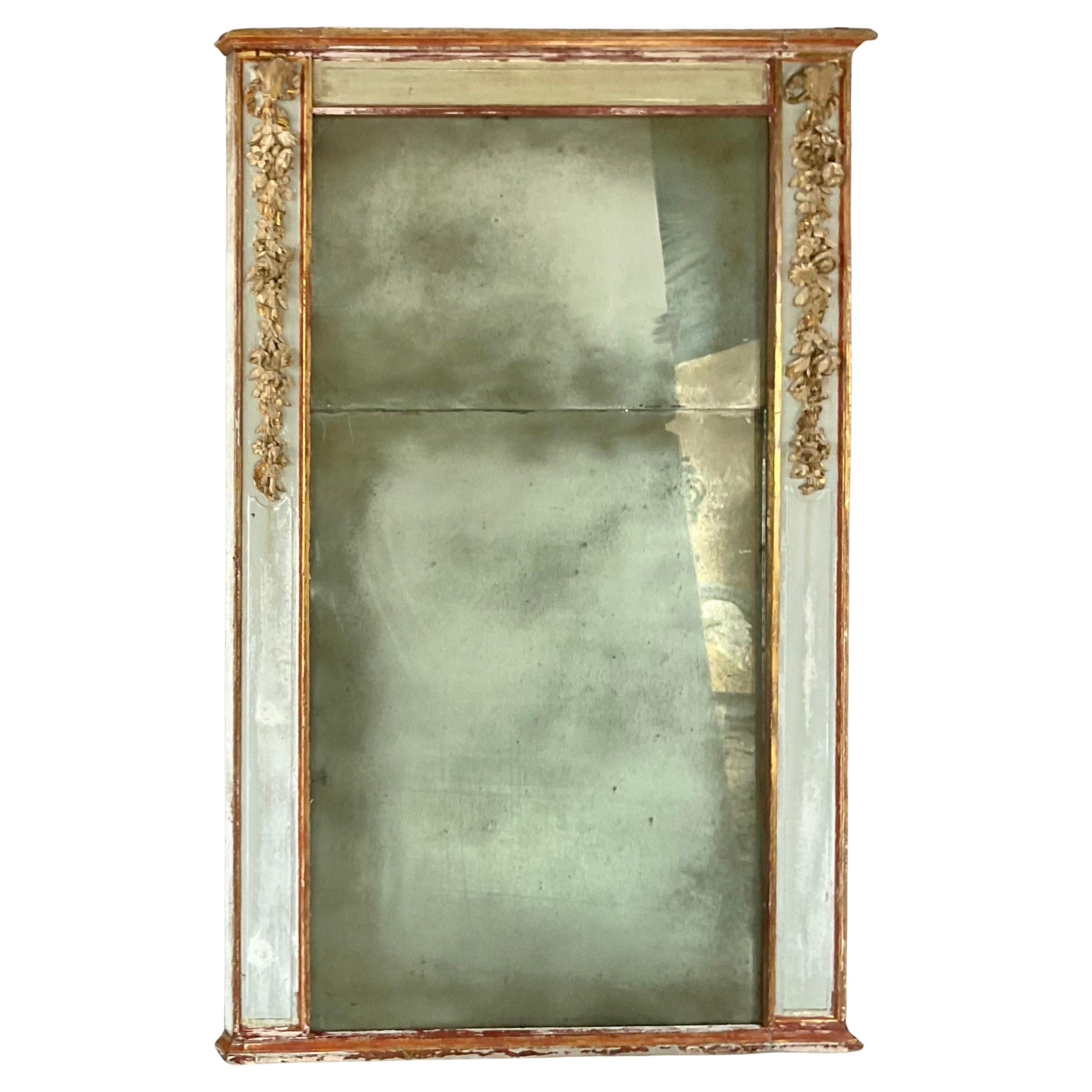 Large 19th Century French Carved Painted and Giltwood Mirror. This Impressive mirror features a rectangular frame adorned with finely carved trailing floral and foliage garlands, a hallmark of neoclassical taste. The original giltwood retains a