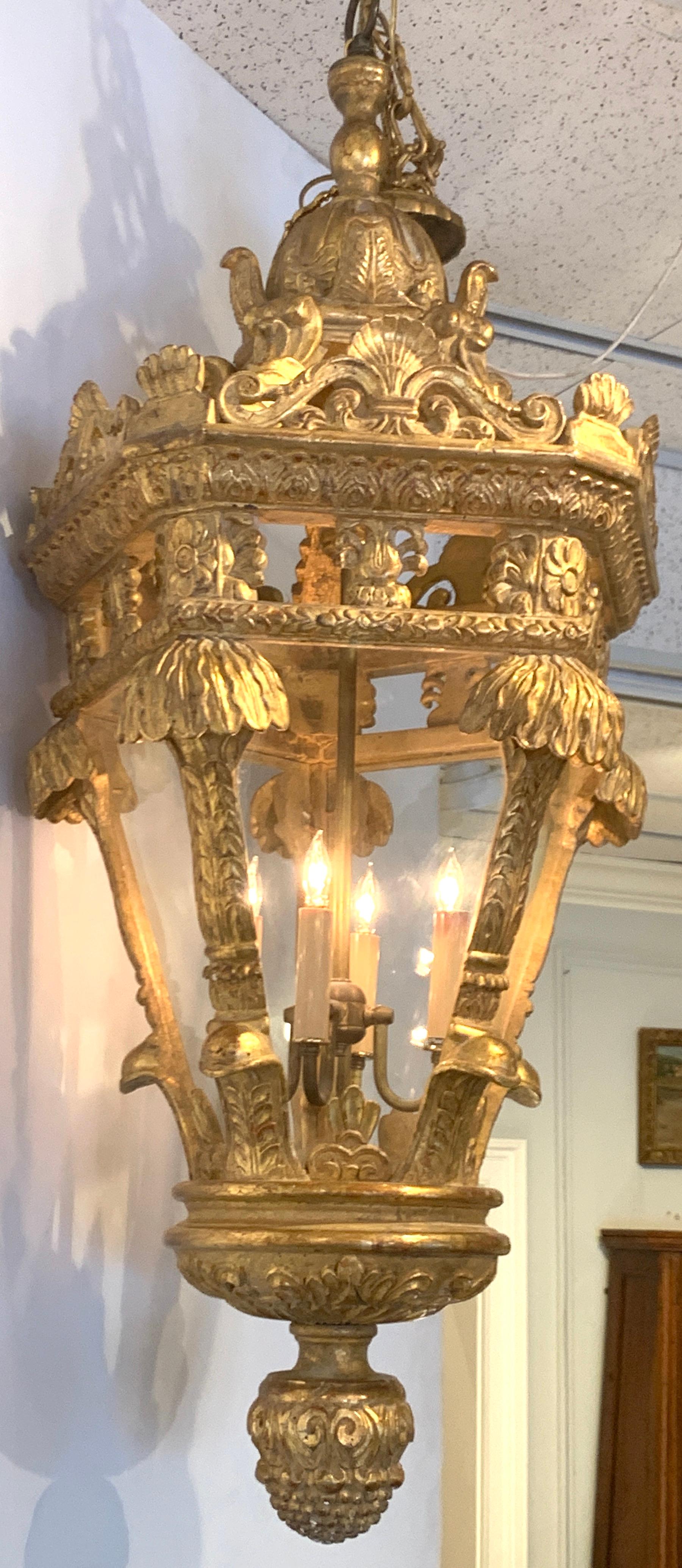 Gorgeous French carved giltwood lantern, of large size, with dome top and palmette and floral carvings. The interior with four candelabra bulbs, ending with an acanthus finial. From the Breakers Palm Beach FL.

     