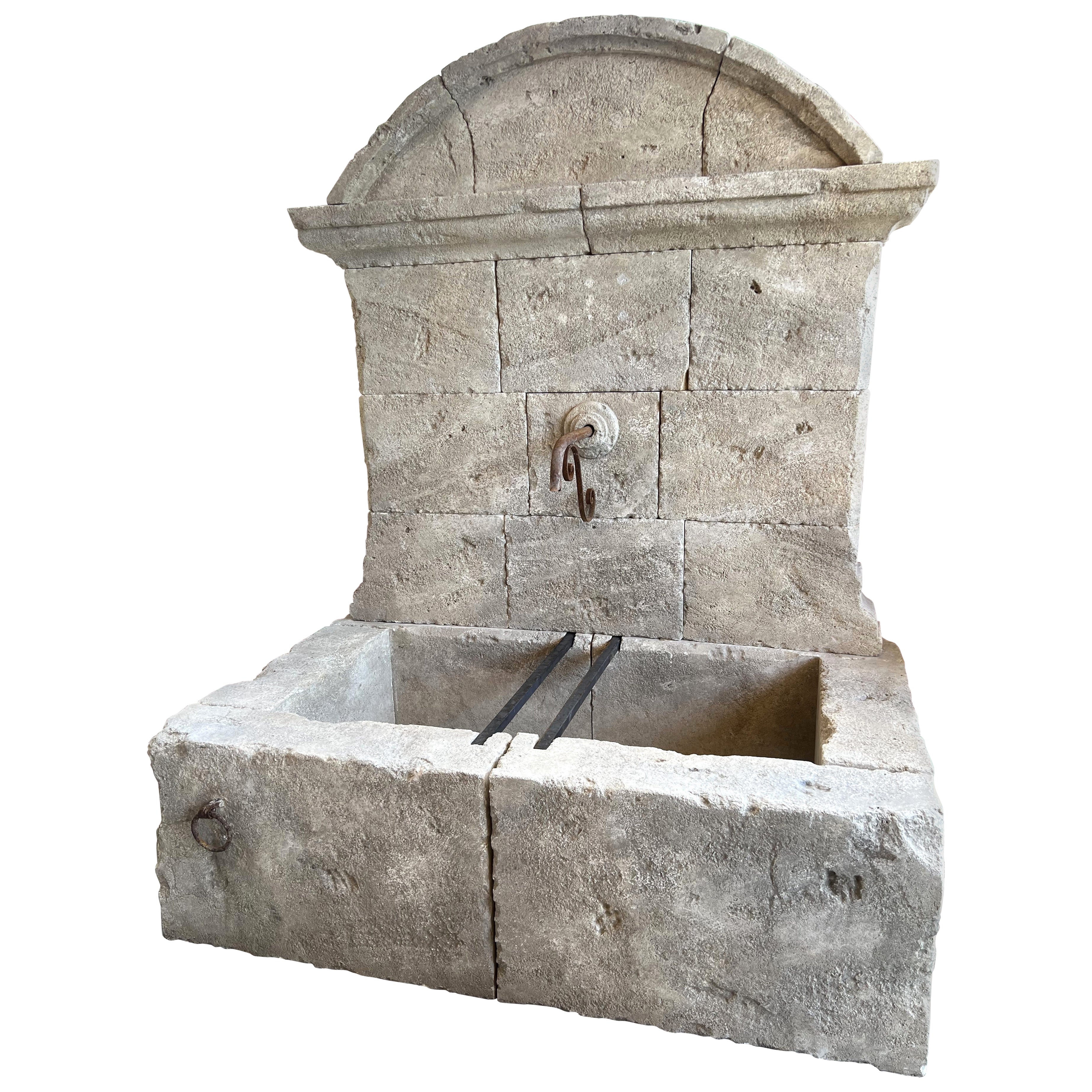 Großer französischer Wandbrunnen aus geschnitztem Kalkstein, gewölbte Krone und gusseiserne Beschläge im Angebot