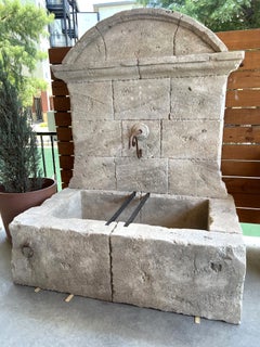 Großer französischer Wandbrunnen aus geschnitztem Kalkstein, gewölbte Krone und gusseiserne Beschläge