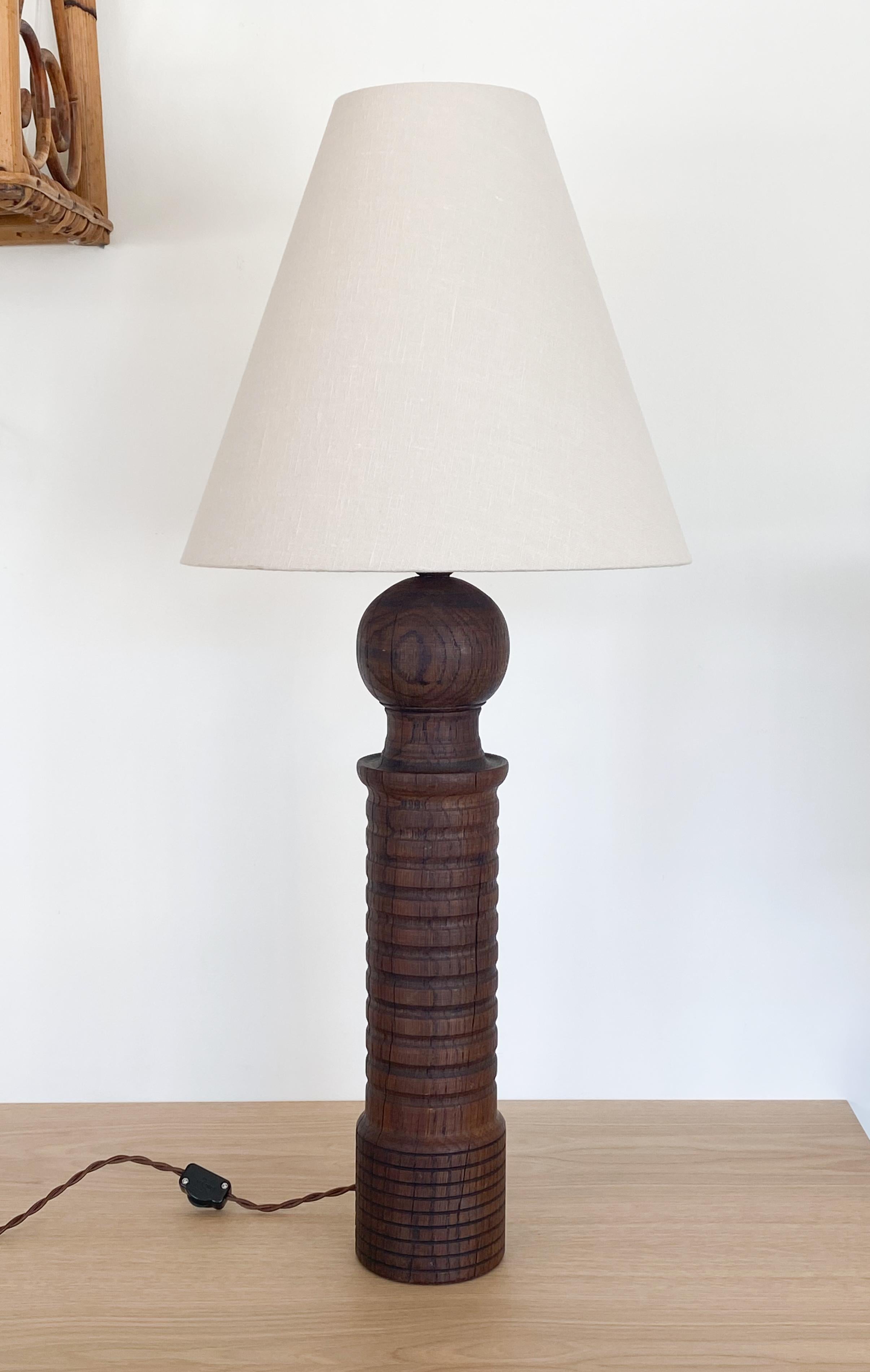 Vintage tall carved wood lamp with linen shade from France. Original wood finish and newly rewired. 

Measures: Shade diameter 13.25