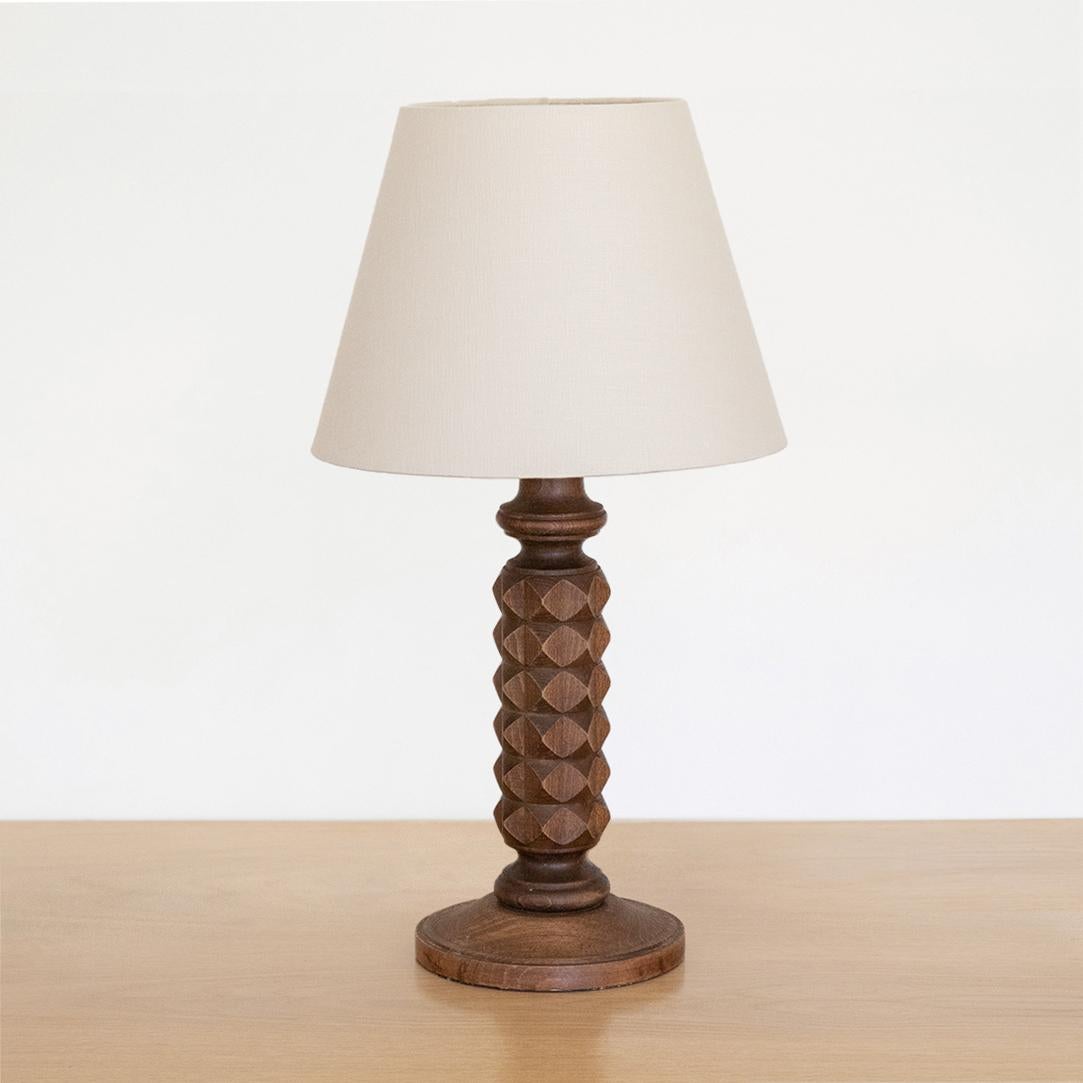 Large hand carved wood table lamp from France, 1940s. Beautiful carved diamond design with original dark wood finish. New ivory linen shade and newly re-wired. 

     