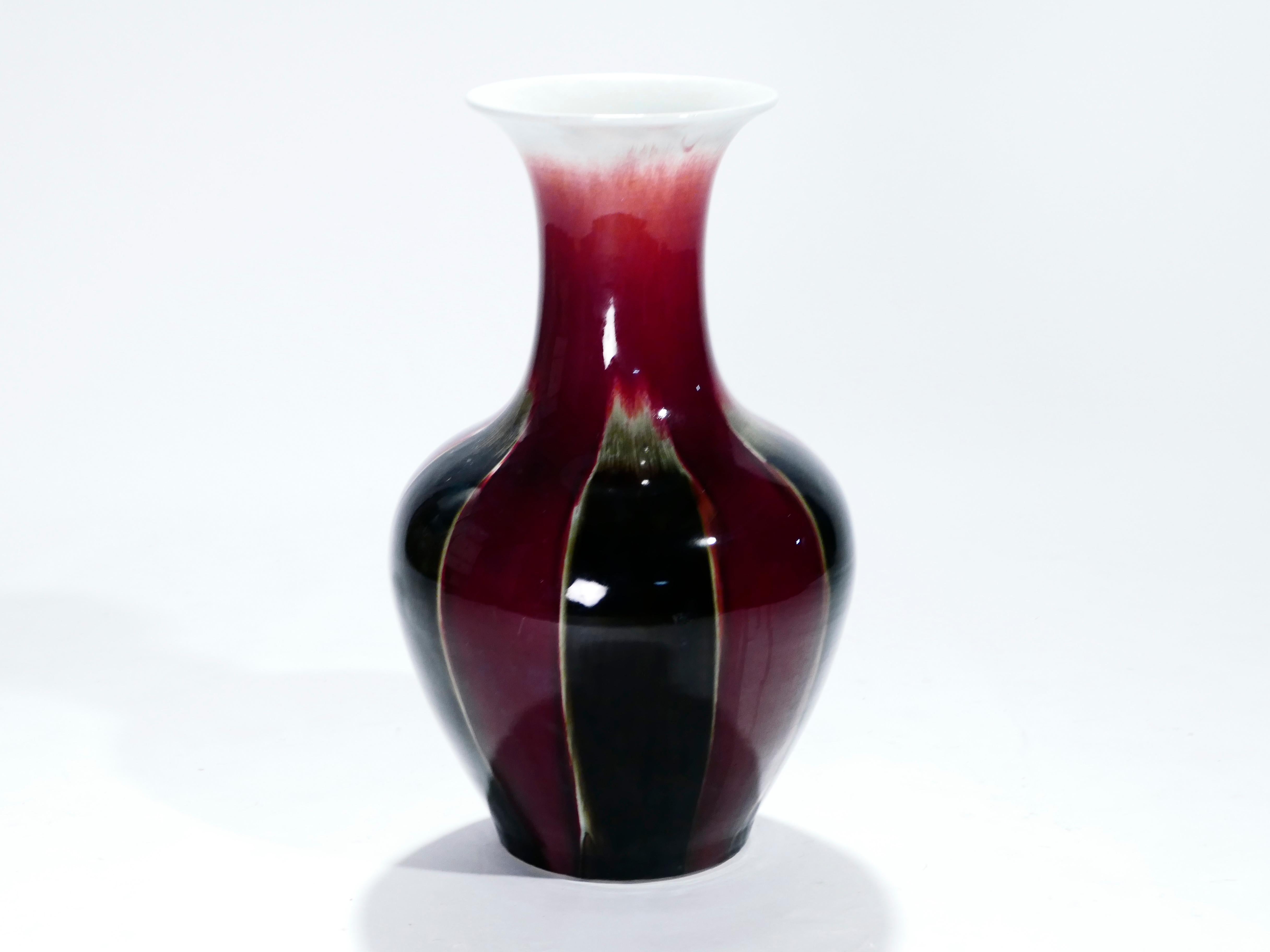 At 67 cms (over 2 ft) tall, this curved vase would be imposing in any space. It was created in the 1960s by a French ceramicist with an ample body and energetic trumpet neck. The rich colors err on the side of dark. Sang de boeuf, or flambé glaze,