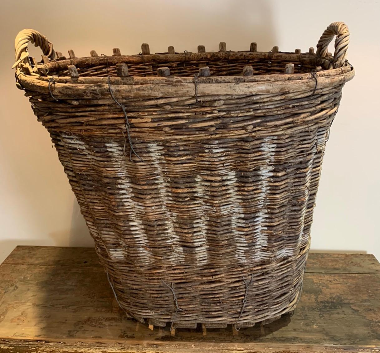 A lovely early 20th century wicker basket from France. This would have been used to harvest grapes for Champagne. This size is much larger than the normal ones. The wicker has a lovely weathered patina.