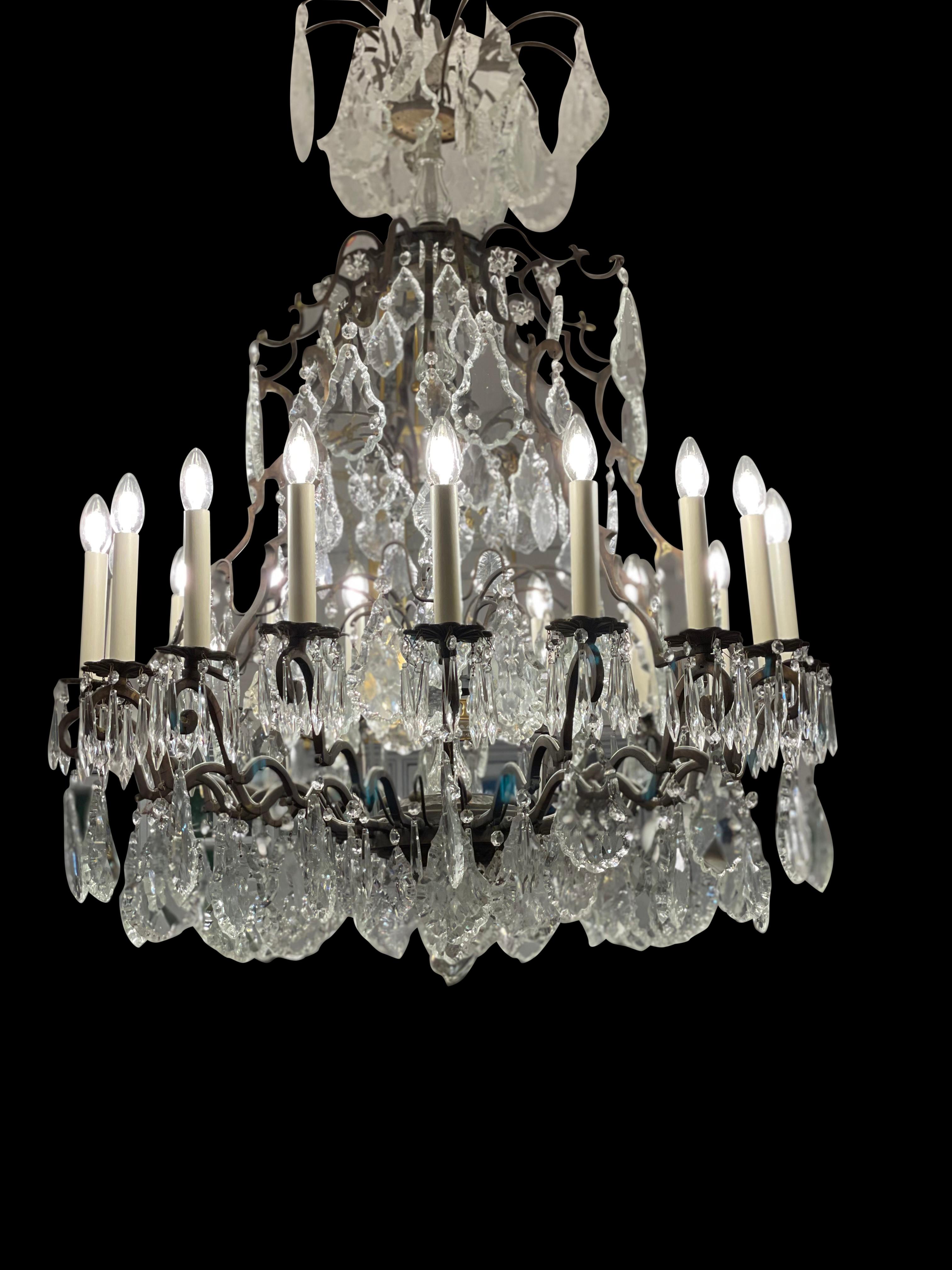 French crystal and bronze 14 light chandelier with a matching canopy and original chain. This particular chandelier is amazing, it's size is fantastic, and it's condition remarkable. Large handcut crystals, an exquisite scrolled frame, and it having