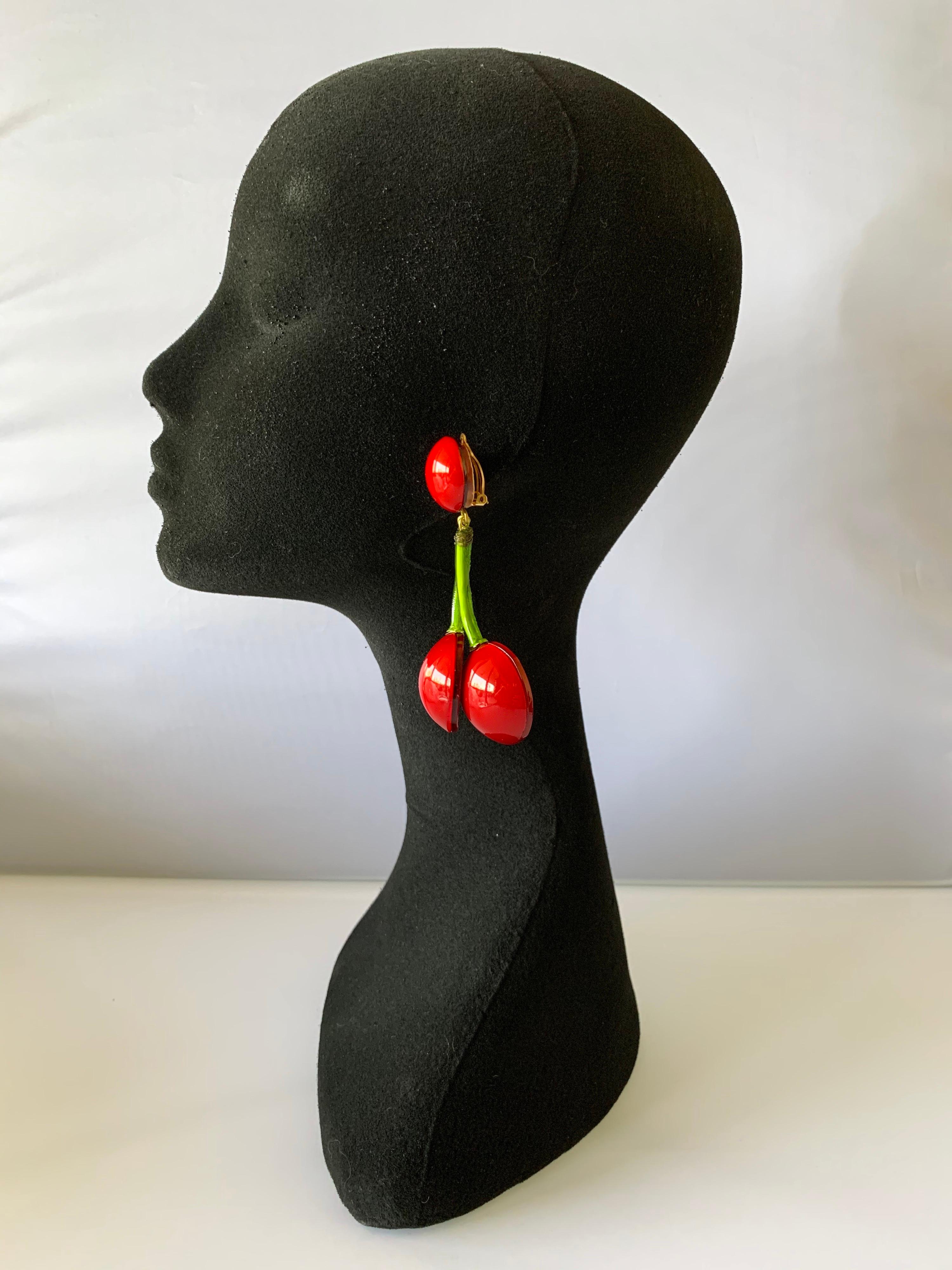 Contemporary artisanal statement clip-on earrings handcrafted in Paris France by Cilea Paris. The large statement earrings are comprised of red and green enameline (resin and enamel) and feature oversized cherries. A unique design with architectural