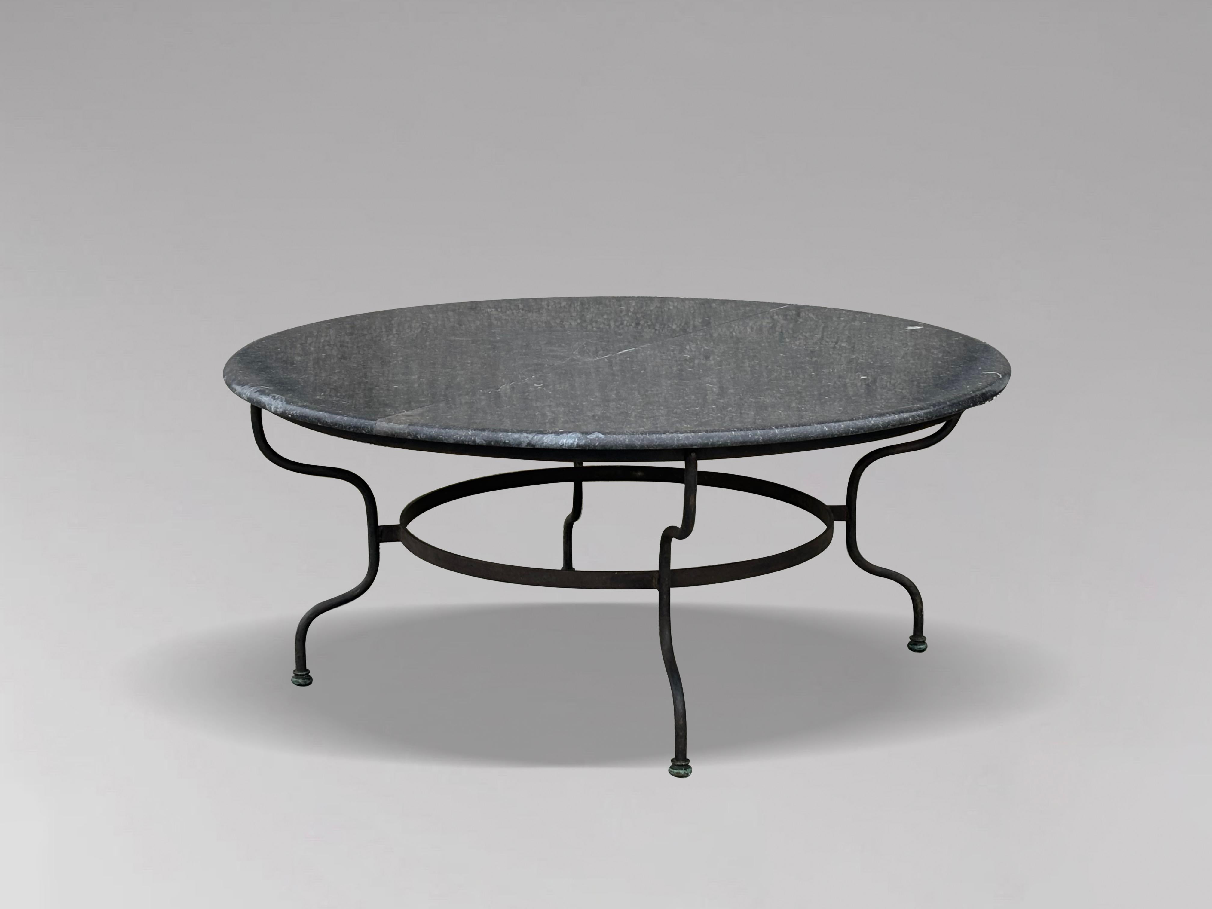 An unusually large and very elegant French early 20th century garden patio dining table. Polished grey granite circular top above a wrought iron base with 4 turned shaped legs connected with a circular stretcher. The circular granite top is divided