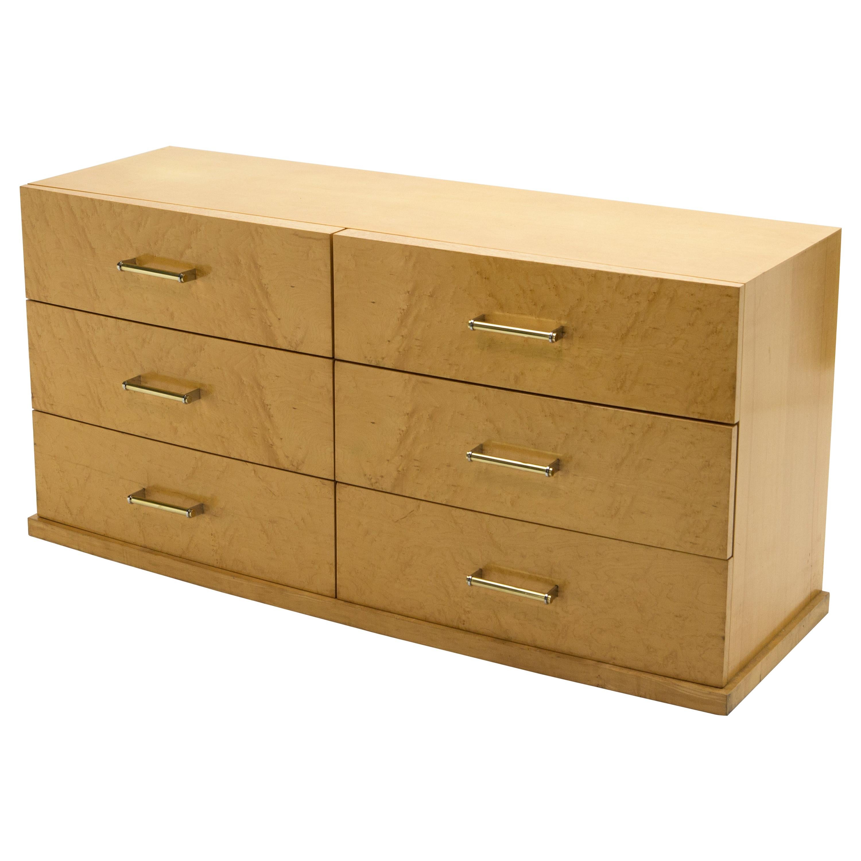 This large 1950s commode chest of drawers would impart a cosy, glowing mood to any space. The warm sycamore wood, geometric shape and curved front, remains looking healthy and smooth 70 years later. Quality brass and chrome handles adorn the front