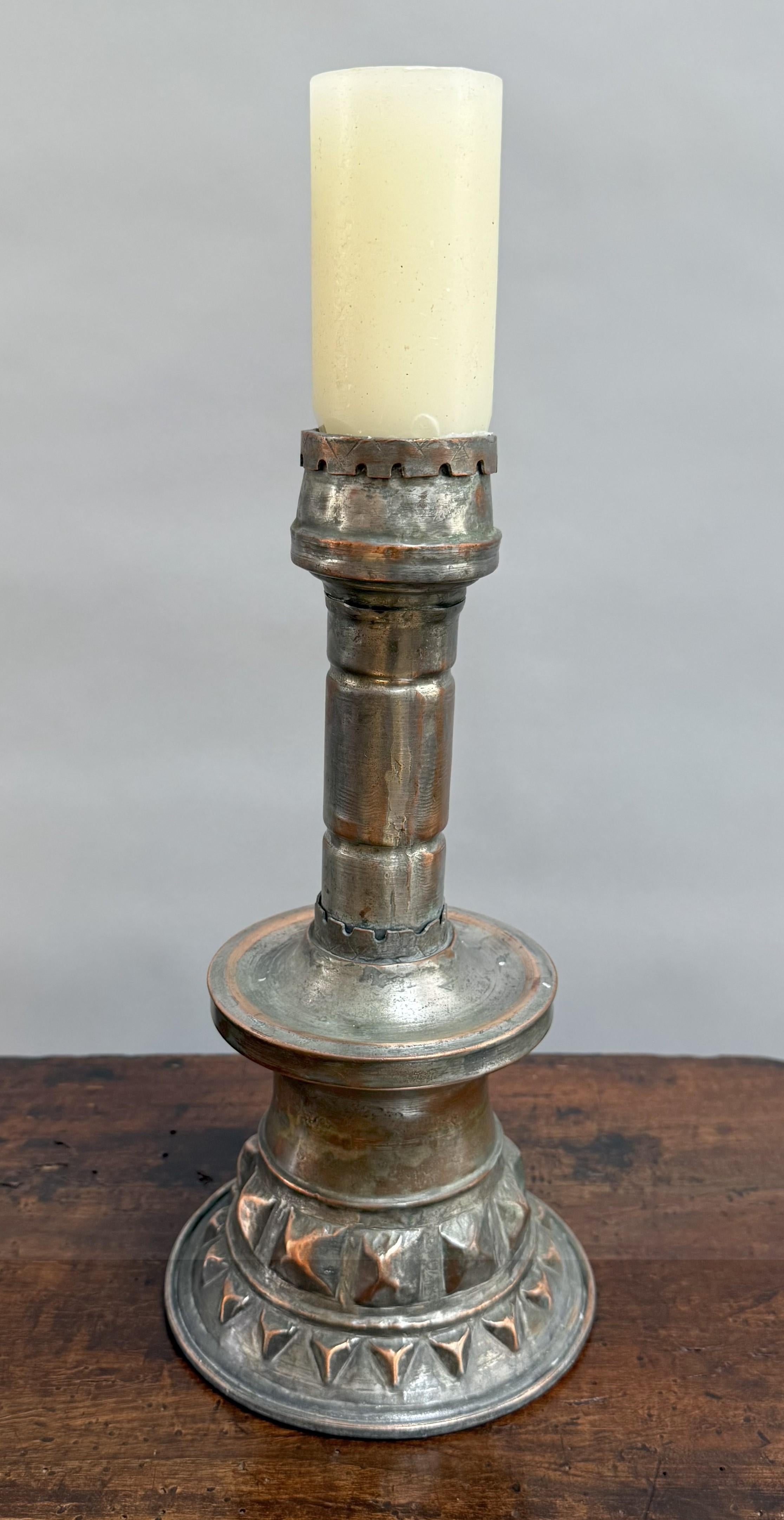 A superb example of late 18th-century French provincial metalwork! This large copper candlestick exudes sculptural presence and timeworn beauty. Hand-forged in Provence around 1780, its bold architectural silhouette is enriched by finely hammered