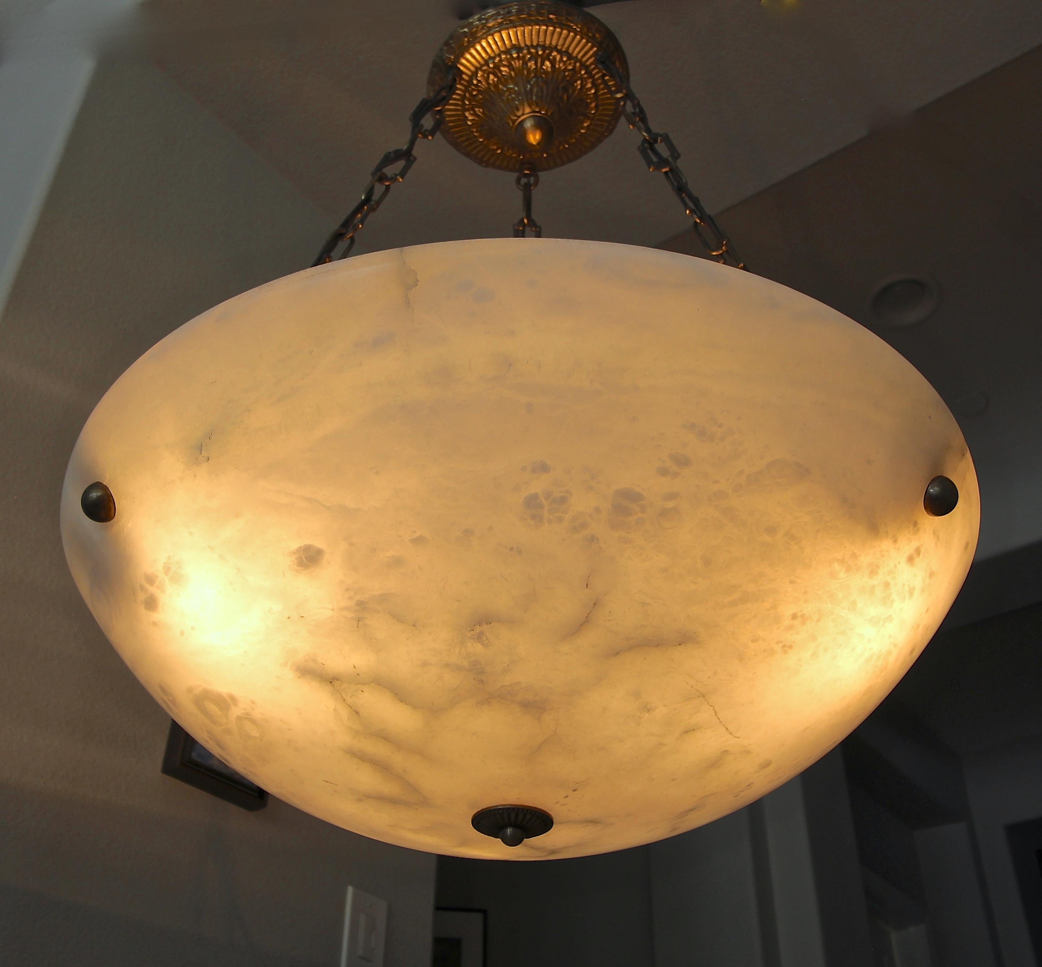 Very large scale alabaster pendant light or chandelier with aged patinated brass fittings in the Directoire style. Newly wired for US, fixture uses three regular A base bulbs.

Measures: Alabaster is 24