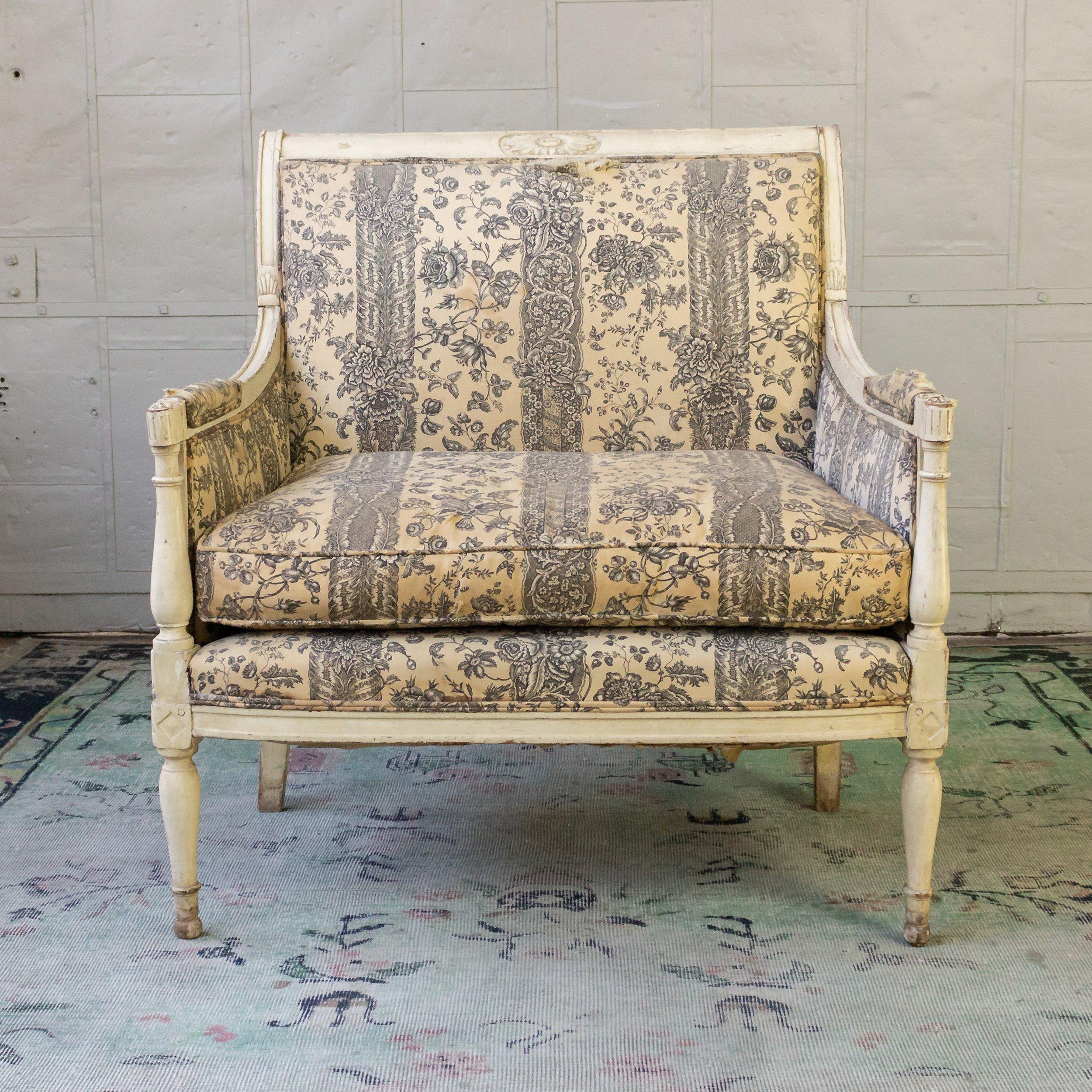 An exceptional 19th century French Directoire style armchair. This large Directoire style fauteuil is a timeless piece of French design. Featuring a beautiful white-distressed wooden frame, this armchair is characterized by its classic 19th century