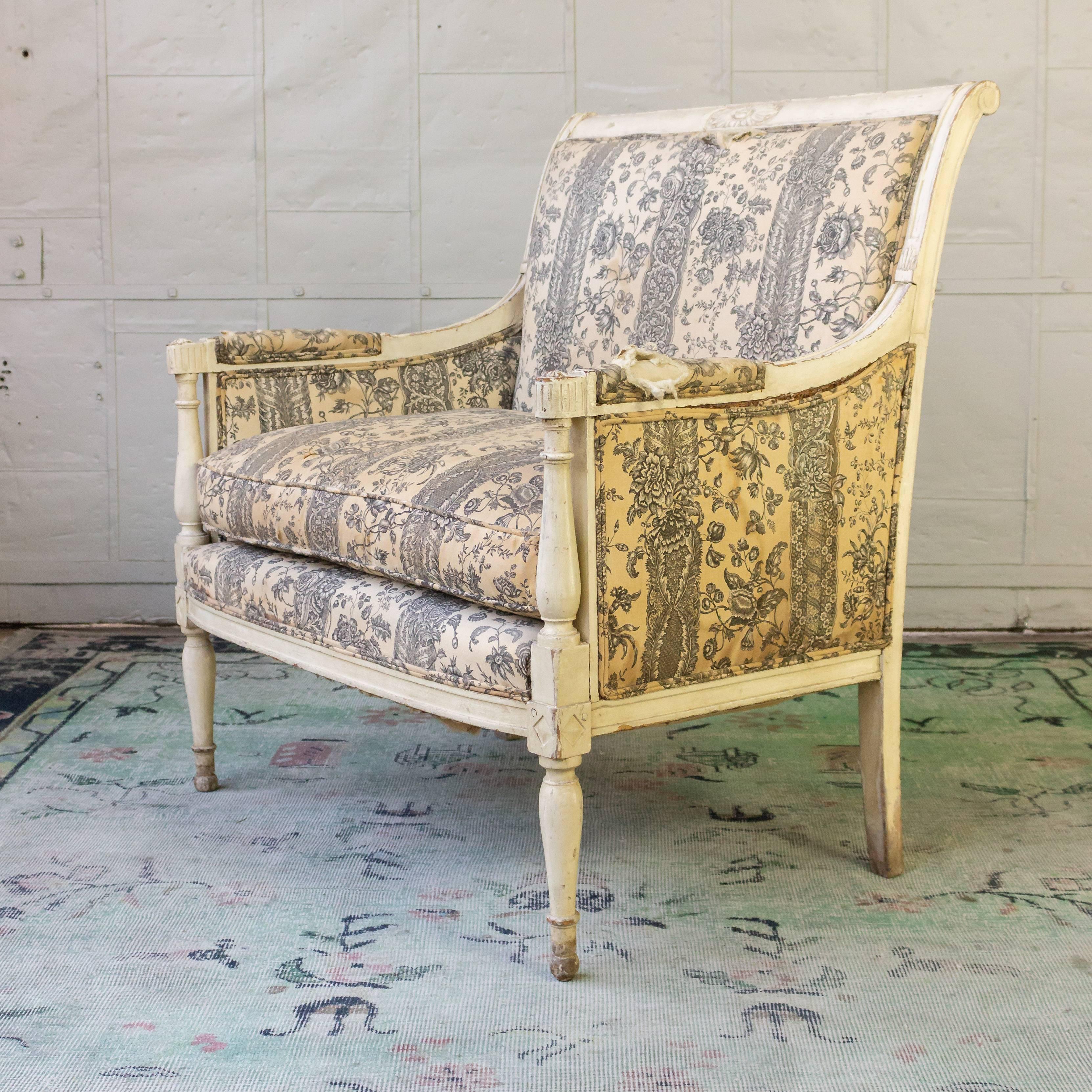 An exceptional 19th century French Directoire style armchair. This large Directoire style fauteuil is a timeless piece of French design. Featuring a beautiful white-distressed wooden frame, this armchair is characterized by its classic 19th century