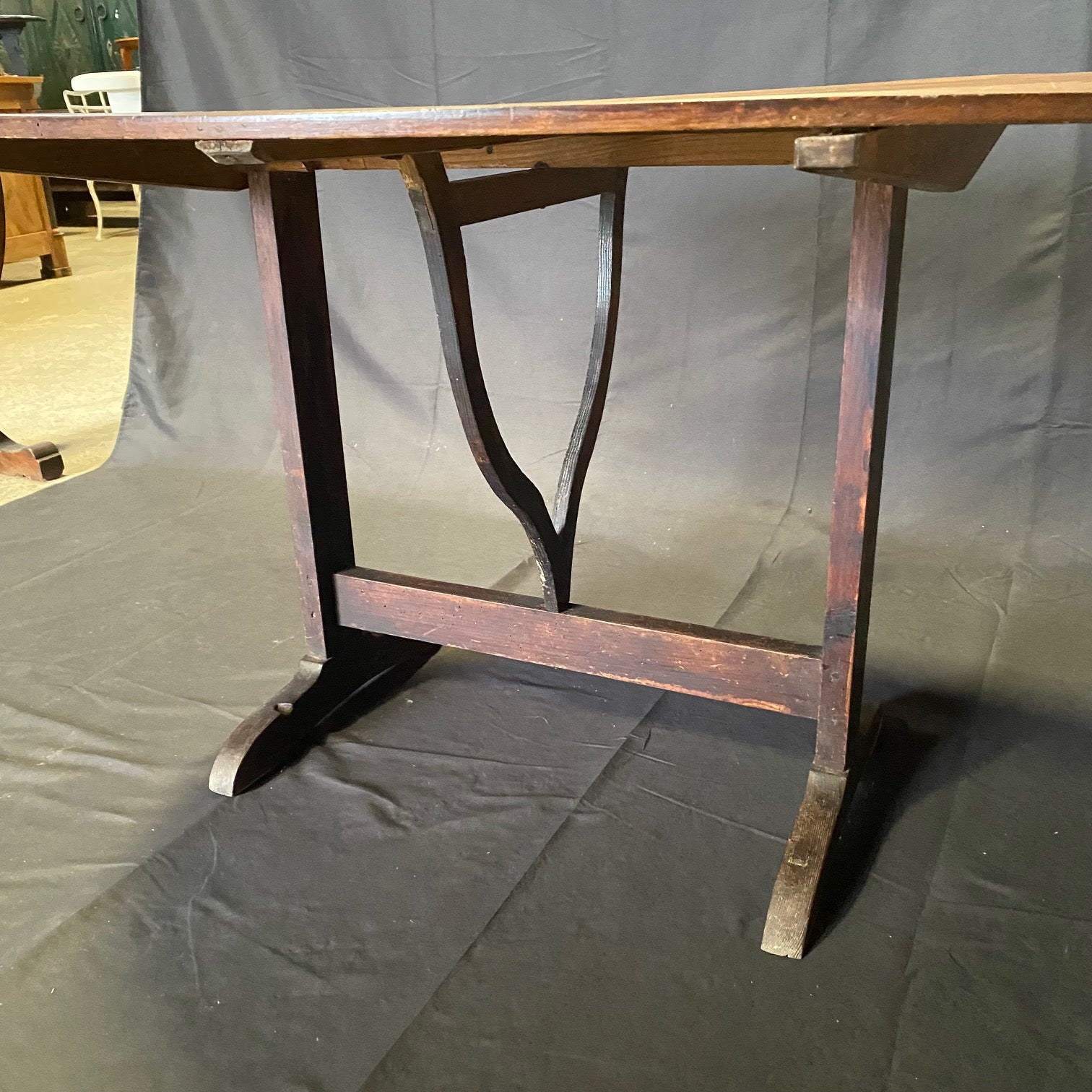 Lovely and large French early oval tilt-top 'table de vendange,' or wine tasting table, circa late 1800s. Oval top upon trestle base with triangular wood lyre mechanism over rounded feet; all hand-carved walnut. Tilt-top fully functional and can be