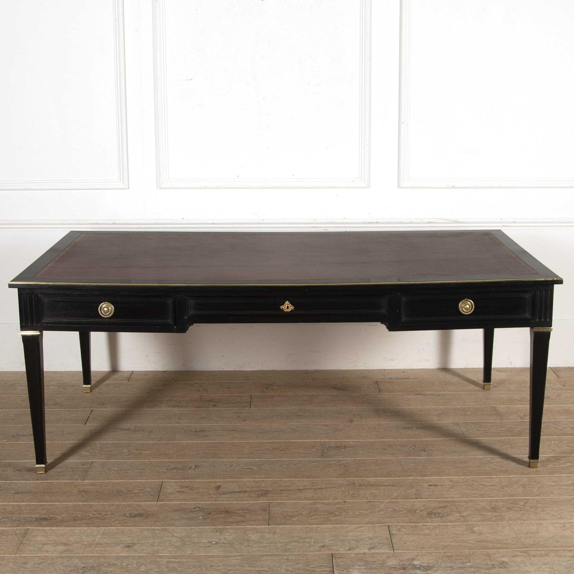 Very smart French Empire ebonised desk.
 
This desk retains its original worn rouge leather inset top. 
 
To the frieze, a long central drawer is flanked by two shorter drawers. 
 
This desk rests on column-style legs and is perfect for a home