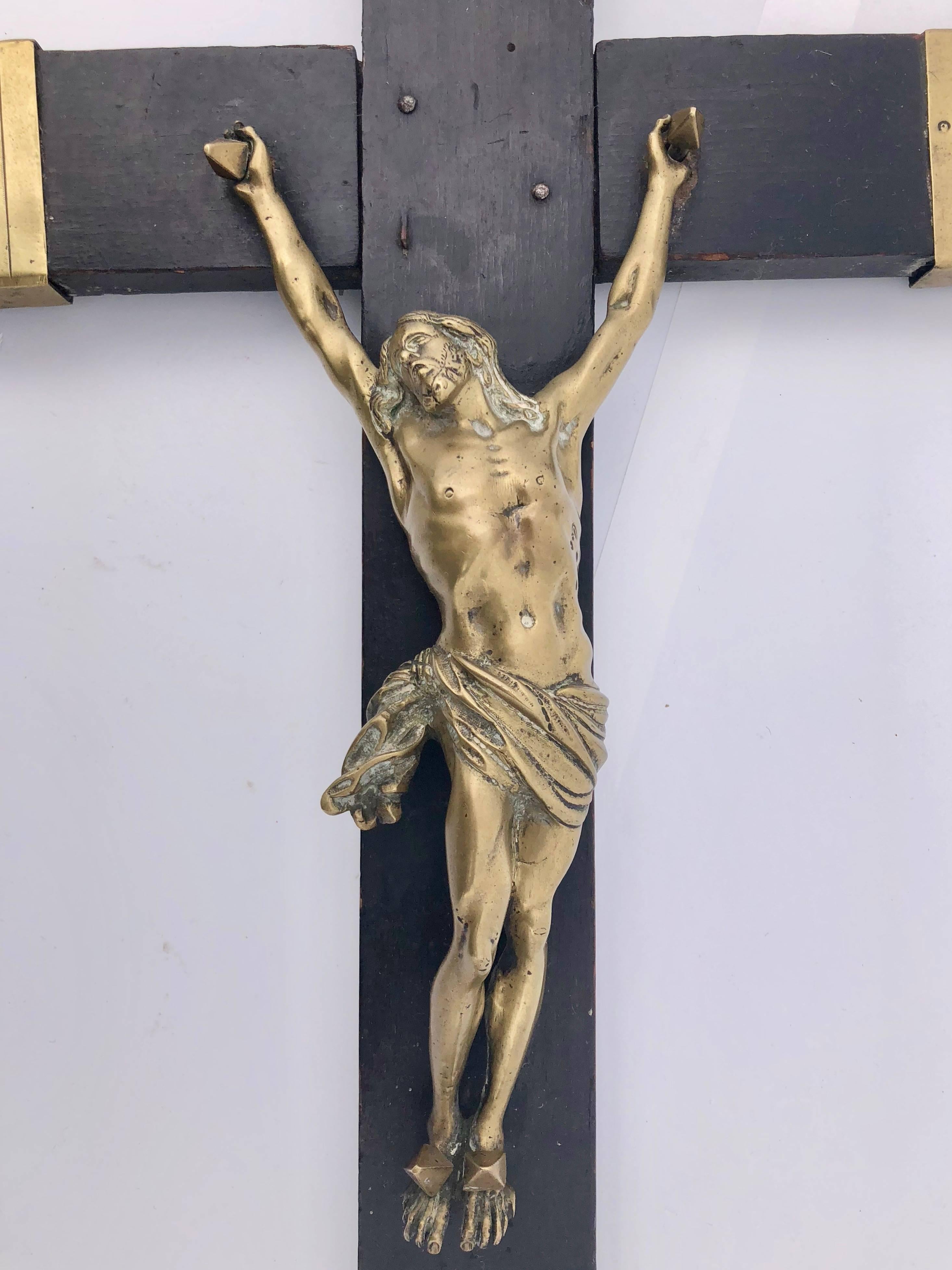 This Louis XVI crucifix is an impressive piece. A stunning large ebonized wood and brass crucifix with brass bound ends and an INRI on a banner at the top and a skull with crossed bones at the base. It is a beautiful 18th century decorative object