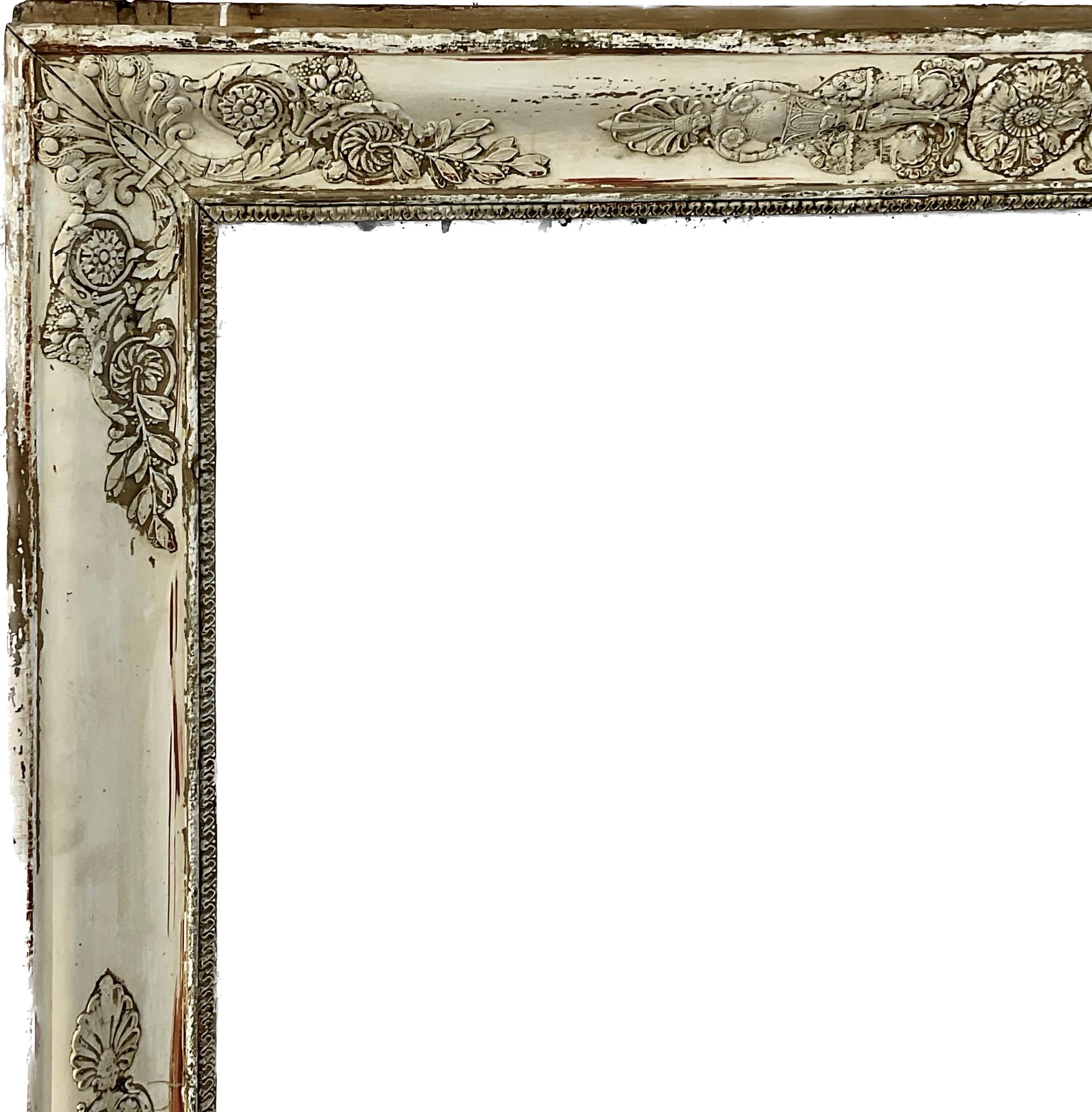 Early 19th century French Empire mirror with original mercury glass mirror. Large scale Empire Gold Gilt mirror is a large statement piece. The gilt finish is worn away to reveal a stunning washed gesso patina. The neoclassical embossed motif is a