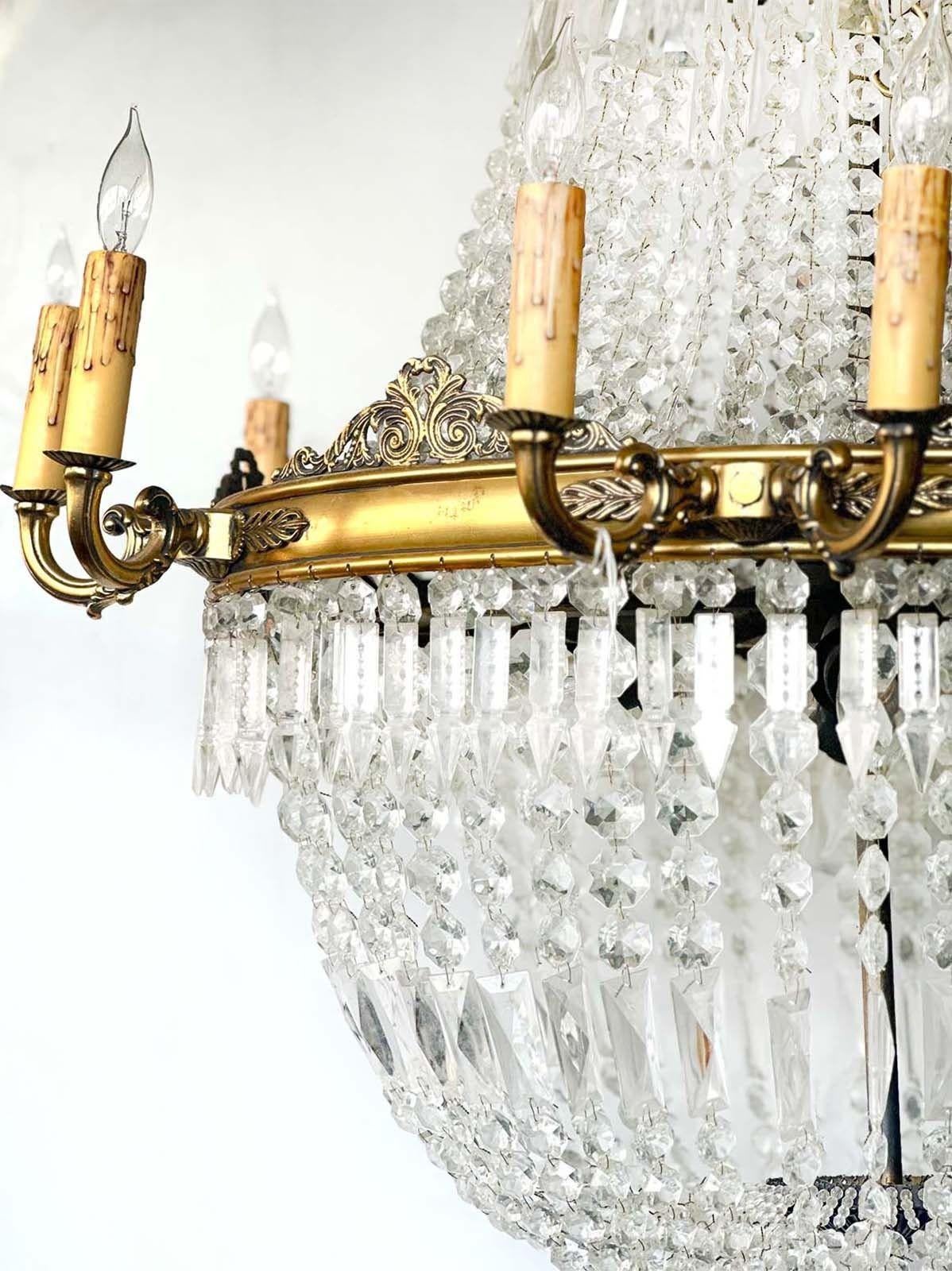 Prächtiger glockenförmiger Kronleuchter im französischen Empire-Stil aus den 1920er Jahren  mit reicher Bronze und feinem Glas. Besteht aus zwölf Kandelabern an der Außenseite und vier an der Innenseite. Diese Leuchte wurde neu verdrahtet, um den