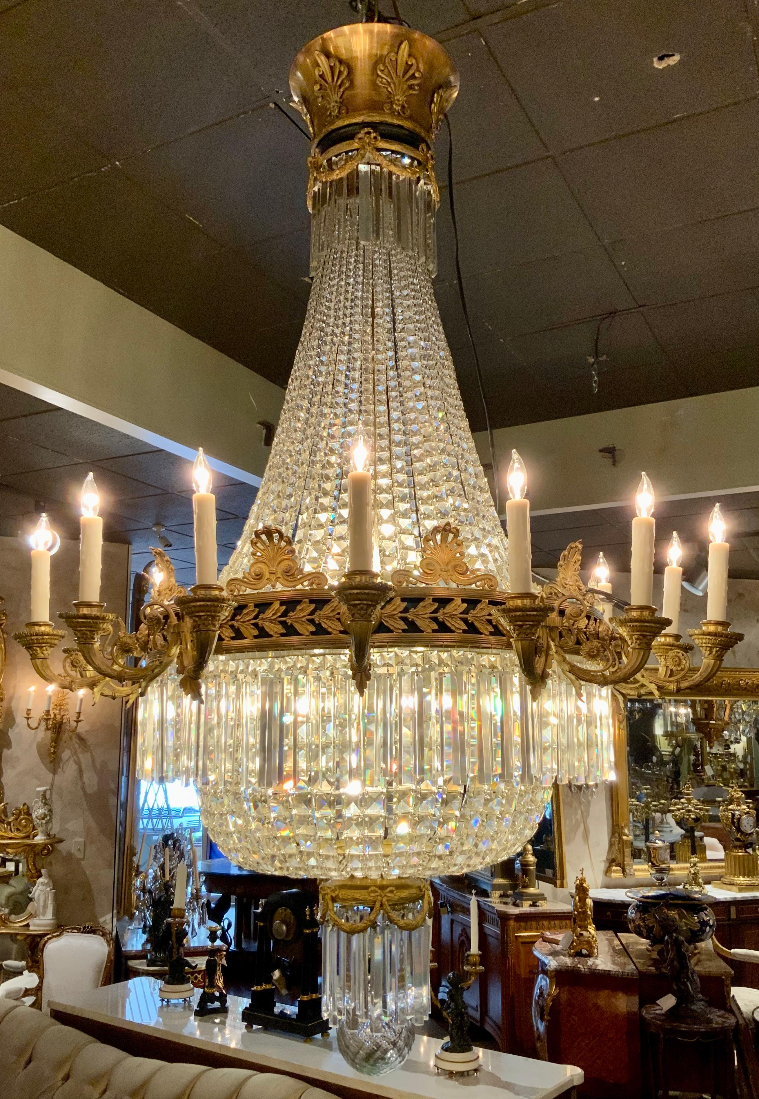 This Empire style chandelier is very large with twenty two
Lights. It has fifteen exterior lights and twelve lights inside
The basket shape. It has a circular bronze dore frame mounted
Against a black inside rim. A handsome leaf and berry