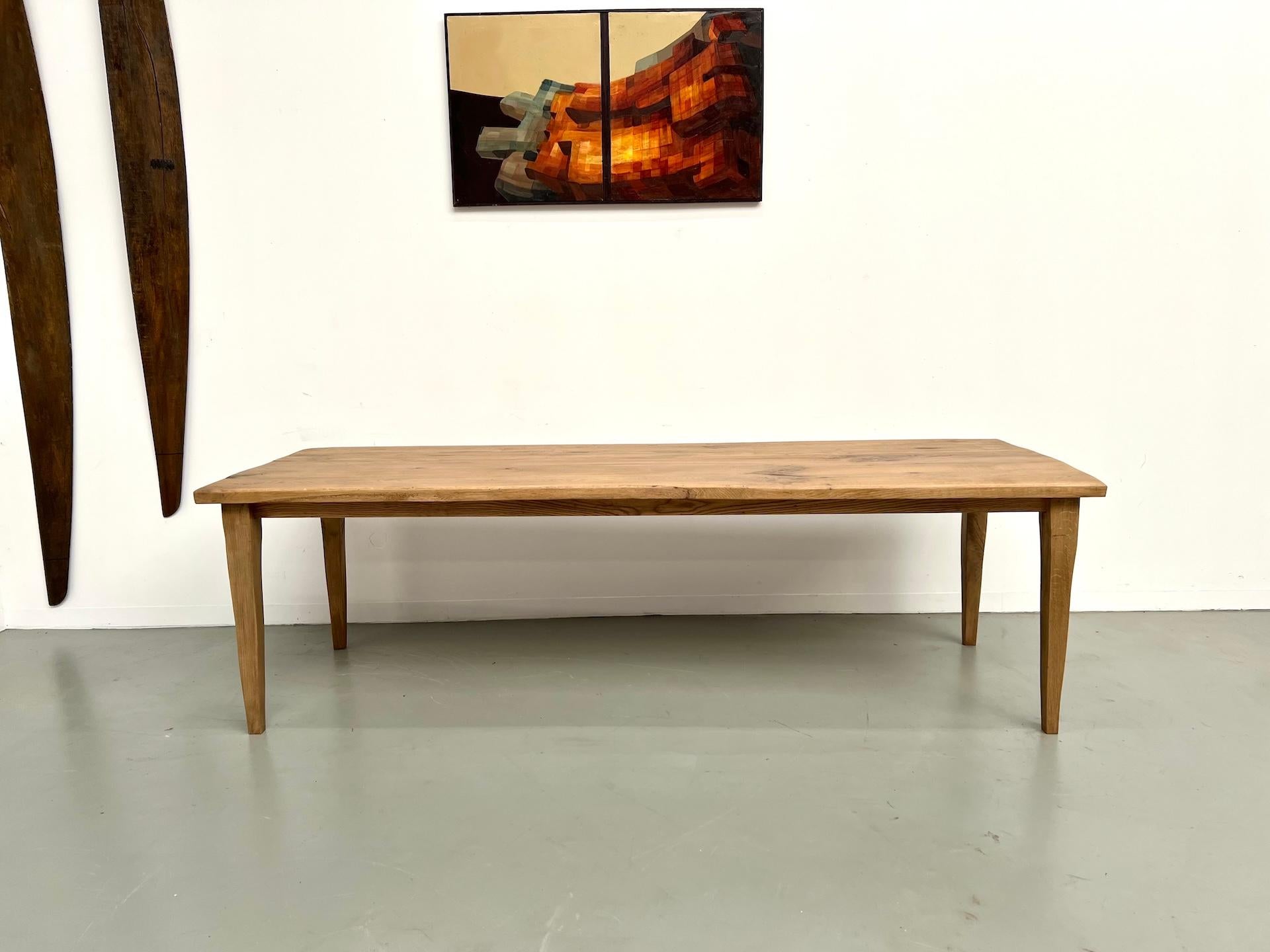 Table de ferme en chêne massif, conçue pour compléter un intérieur conçu par un architecte.
Le plateau en chêne centenaire, d'une épaisseur de 4,5 cm, présente des veinures subtiles et des bords légèrement irréguliers qui soulignent son