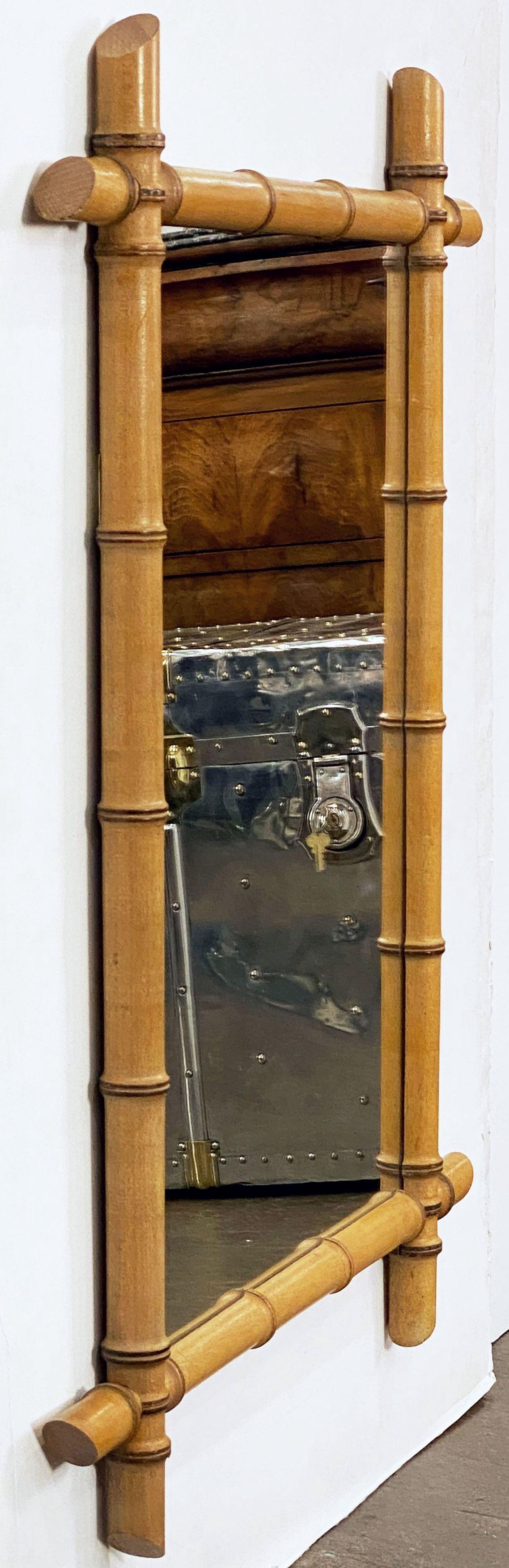 Un grand miroir rectangulaire français en faux bambou du début du 20e siècle, avec un cadre rectangulaire en faux bambou tourné avec des coins entrecroisés entourant une plaque de miroir centrale. 
Peut être affiché verticalement (portrait) ou