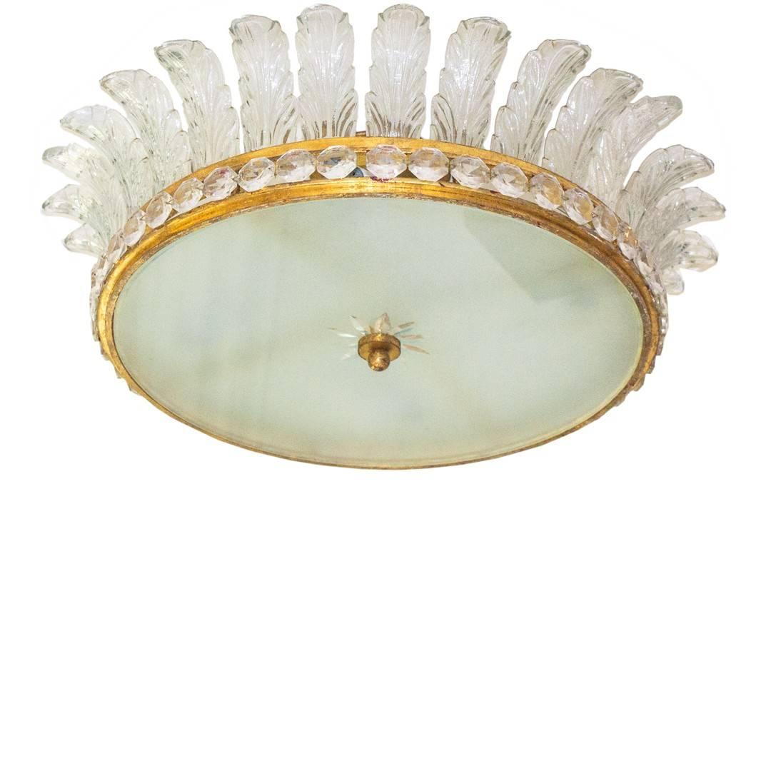French gilded bronze flush mount fixture with crystal palms and encompassed with faceted crystal cabochons. This elegant fixture has a frosted glass bottom with an etched star that is affixed with a gilded bronze mount, circa 1960s.